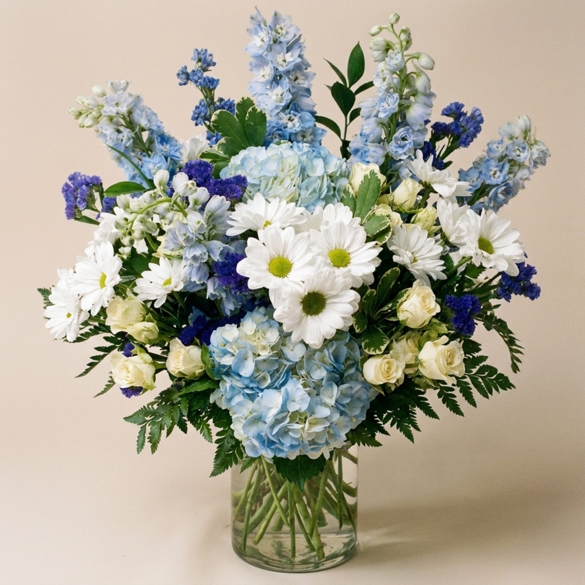 Blue and white mixed bouquet in a clear glass vase