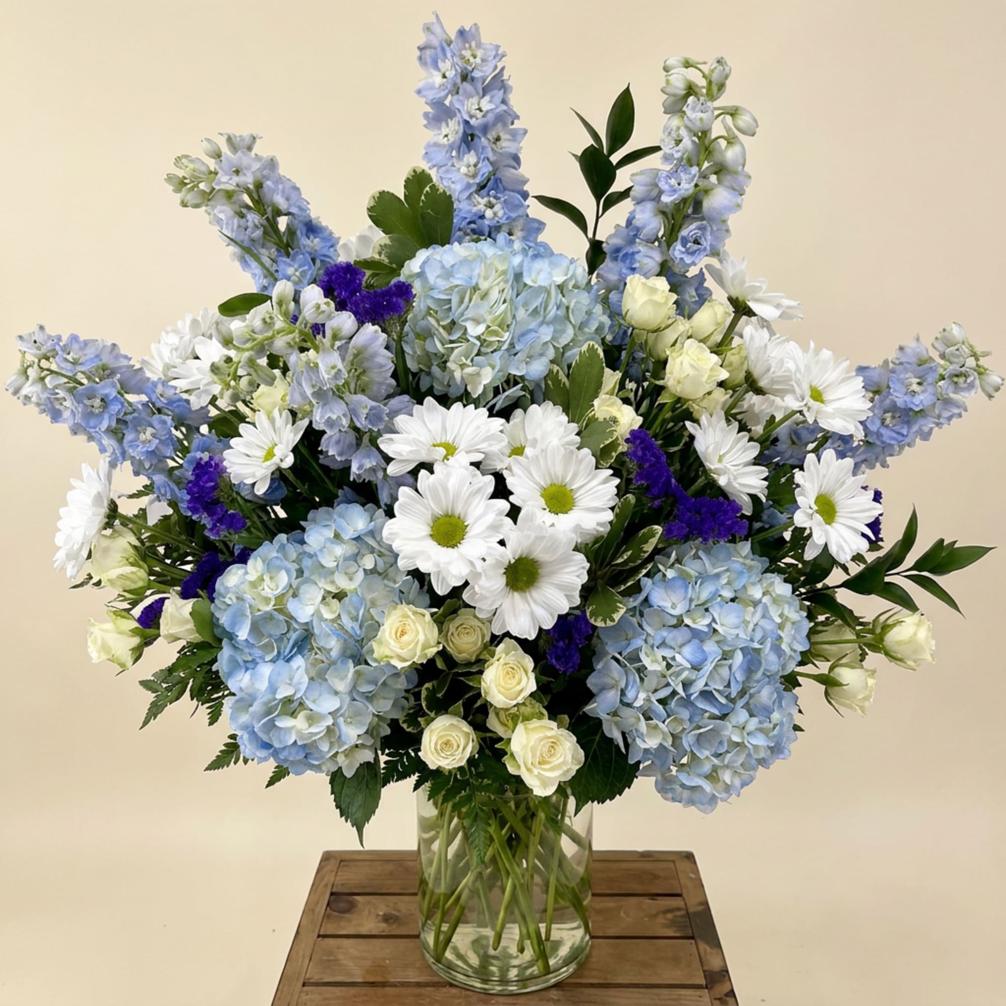 Blue and white mixed bouquet in a clear glass vase