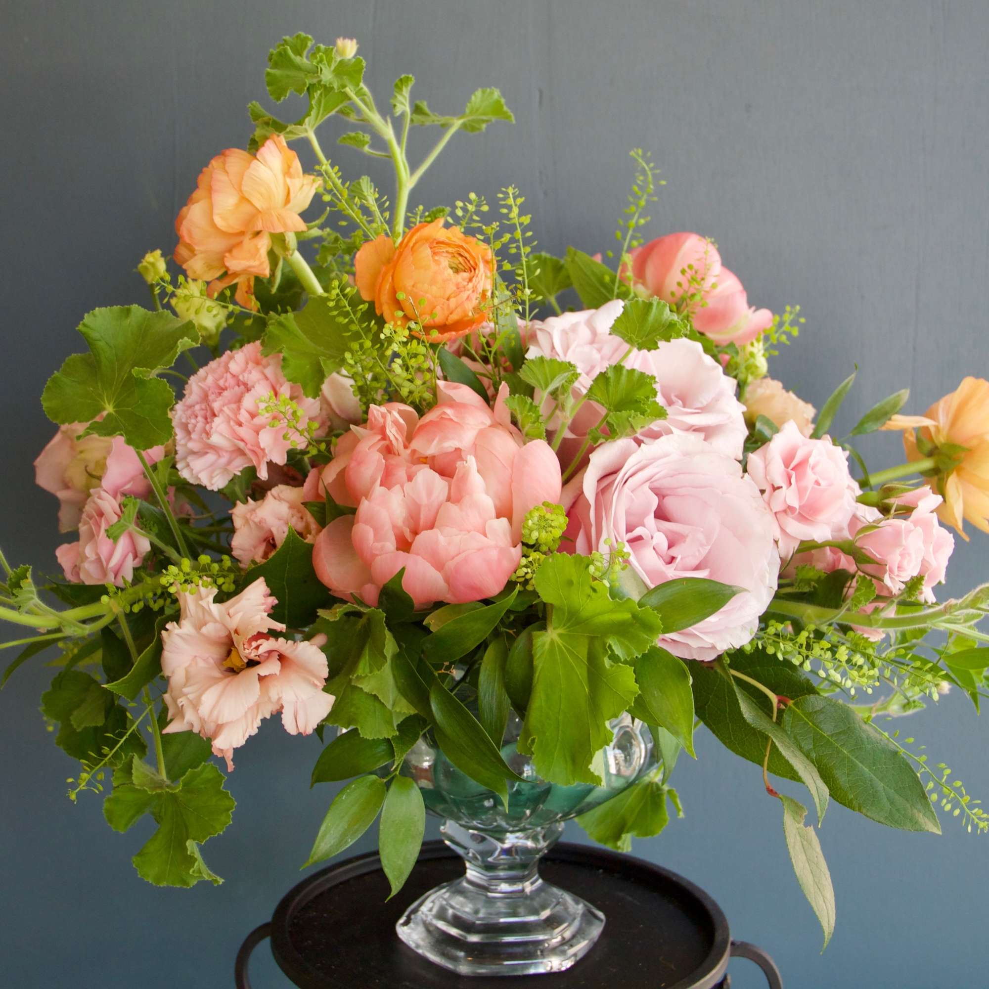 Pastel pink and peach flower arrangement in a clear glass vase