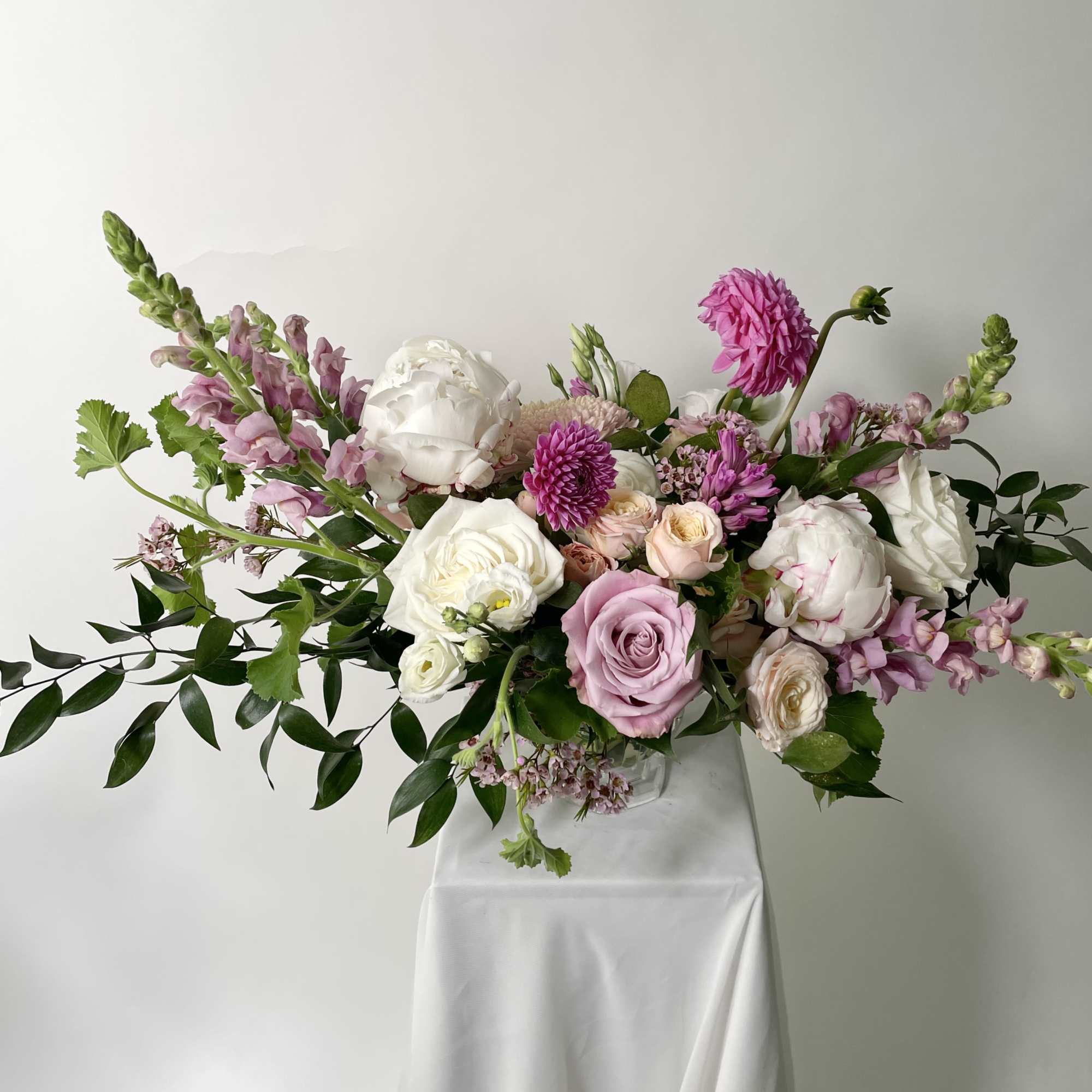 Large pink and white floral arrangement in a clear vase