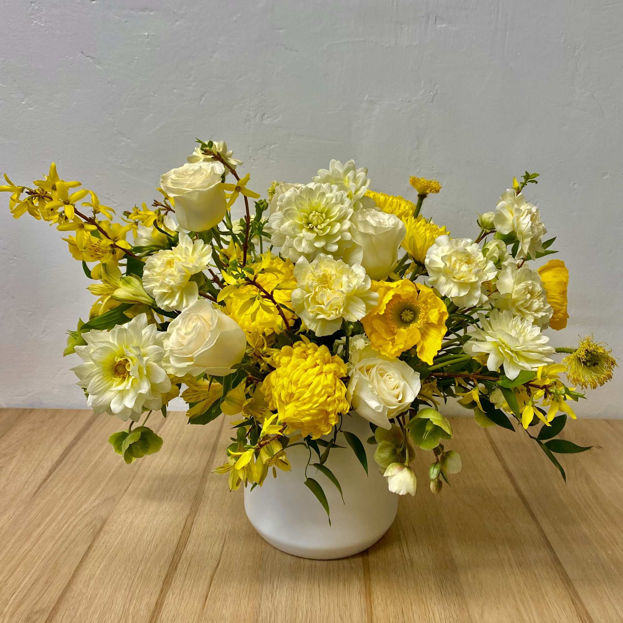Yellow and white flower arrangement in a white vase