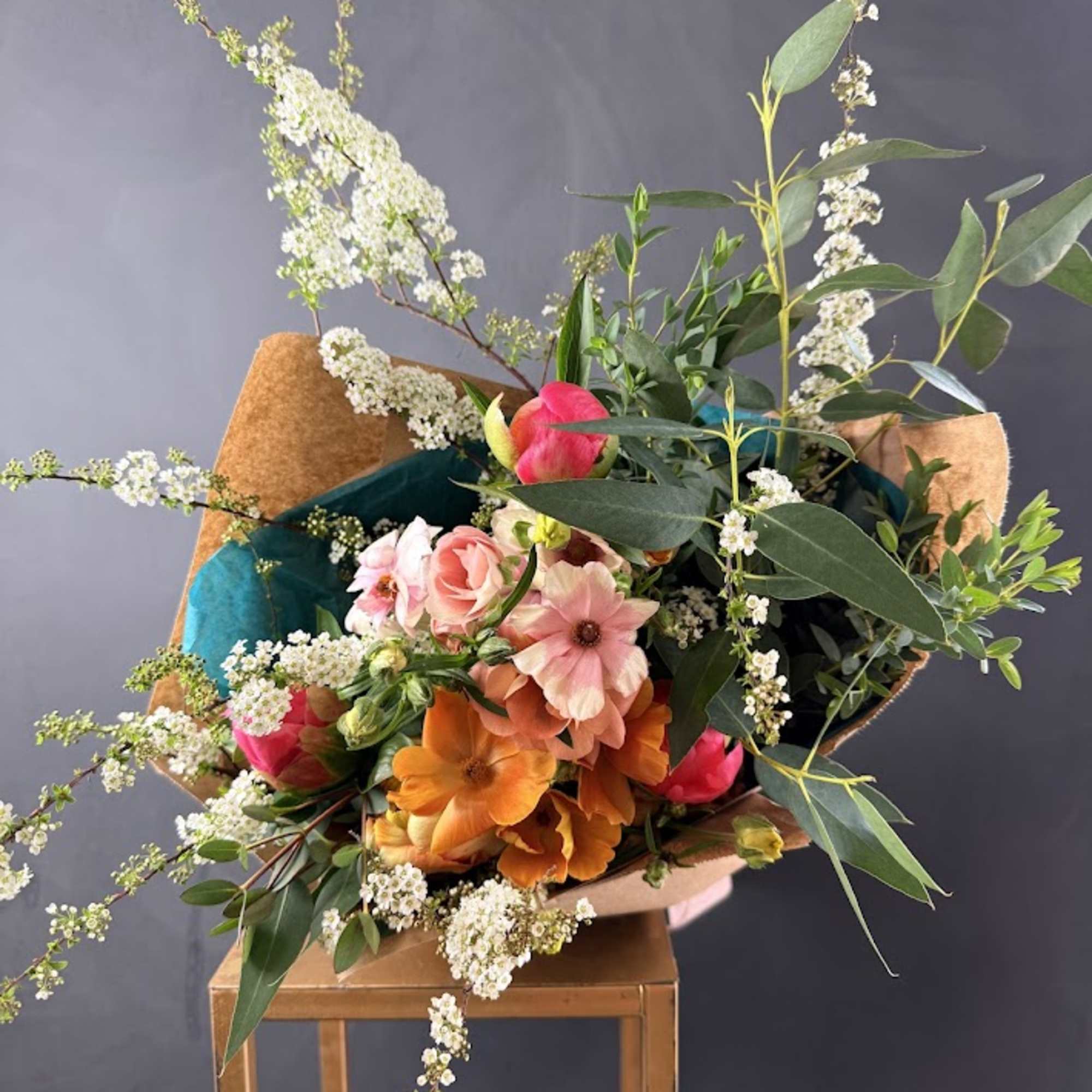 Bouquet of pink and orange flowers with white filler and greenery