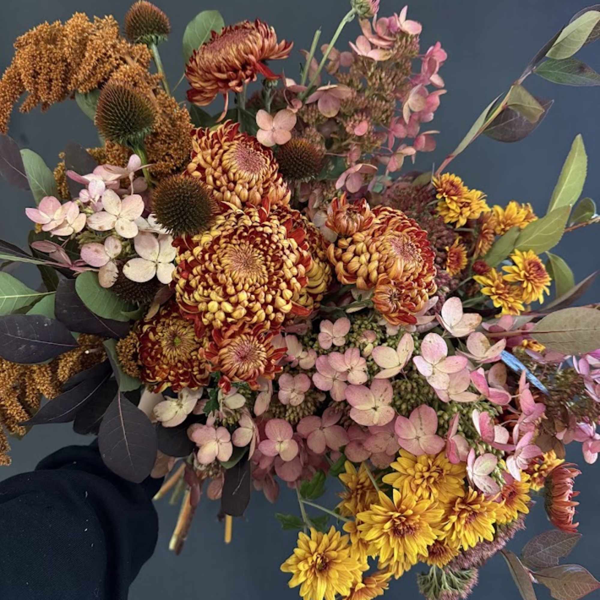 Bouquet of orange and yellow chrysanthemums with pink hydrangea clusters