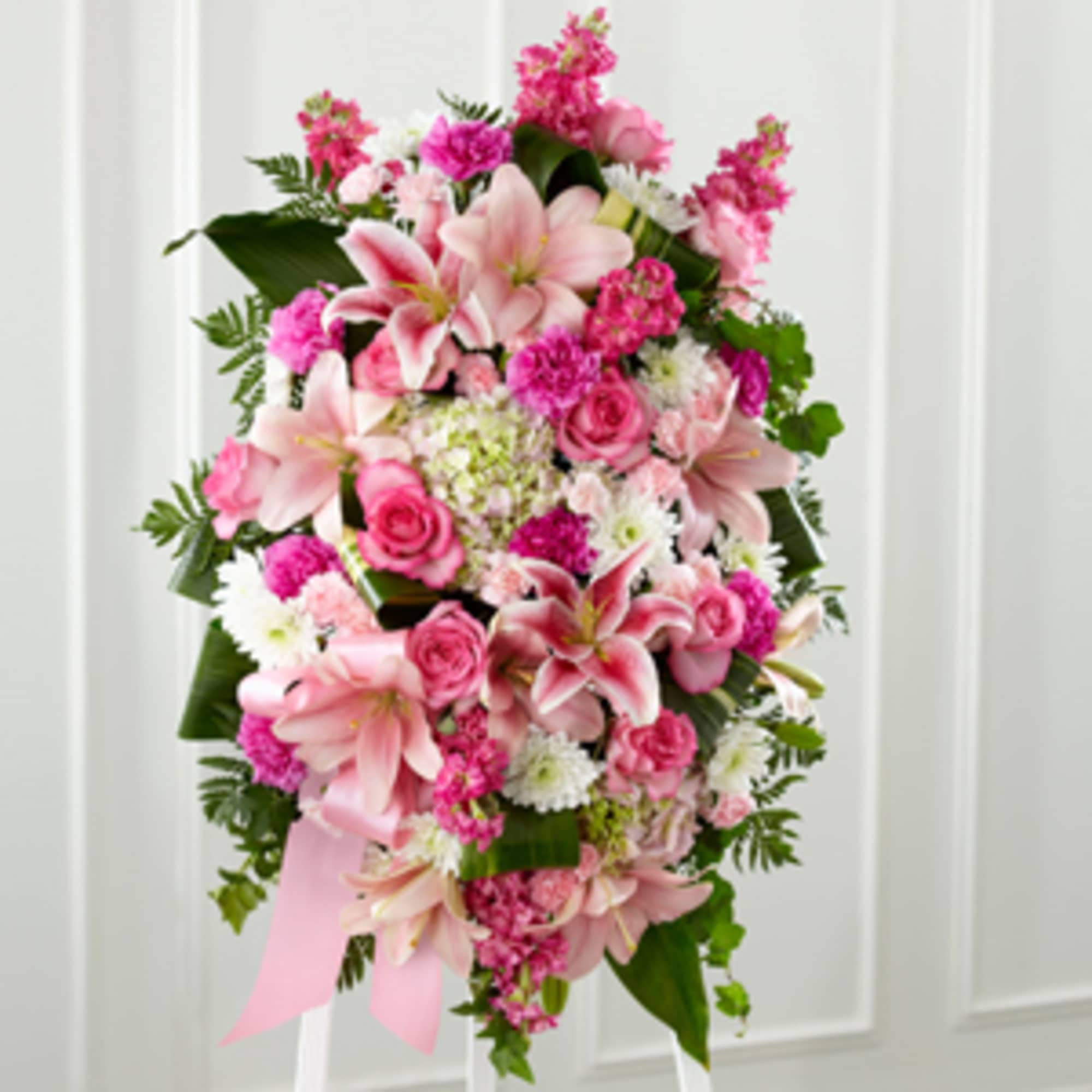 Tall pink and white standing spray with lilies, roses, carnations, and mums on an easel