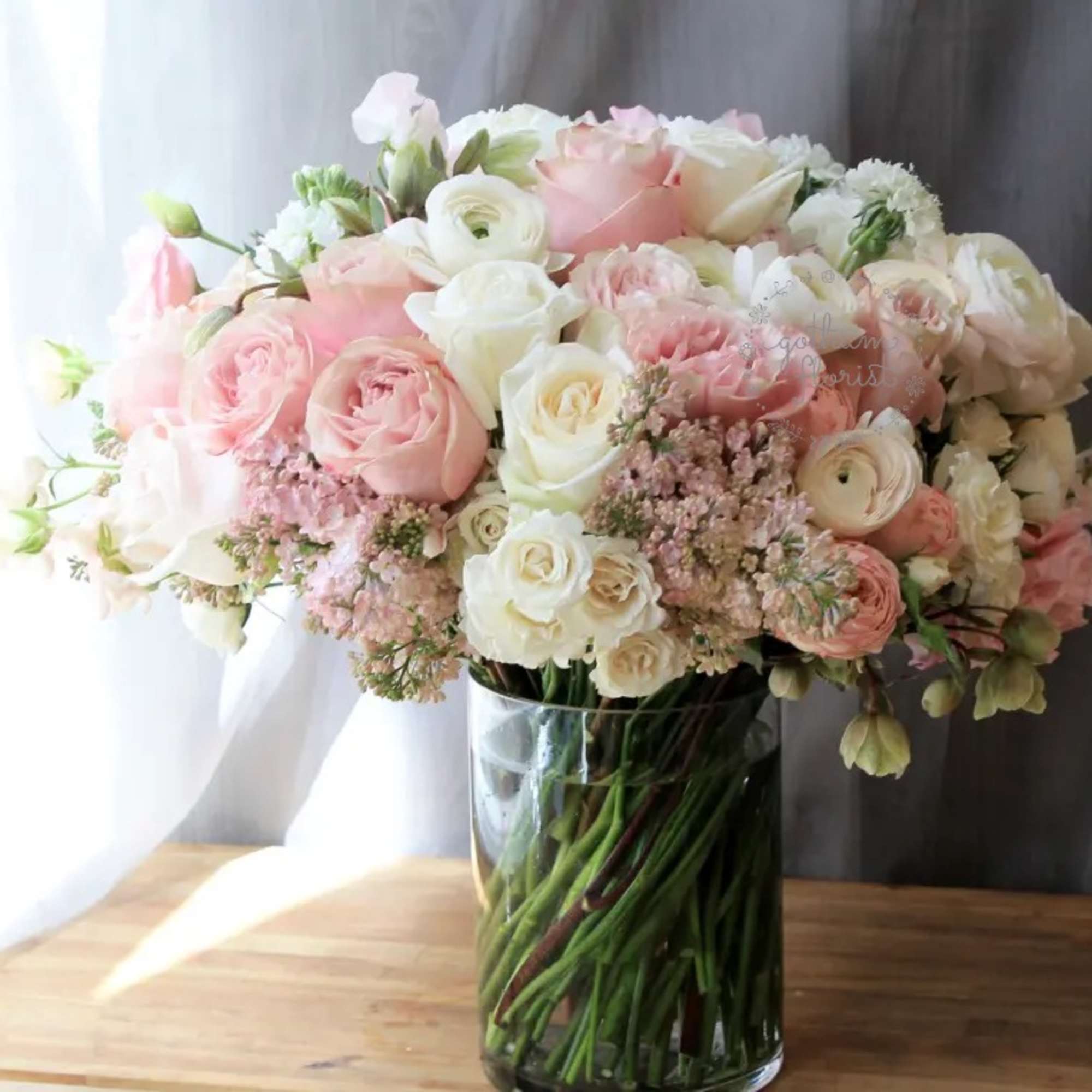 Soft pink roses with creamy white roses, elegant ranunculus, sweet pea and