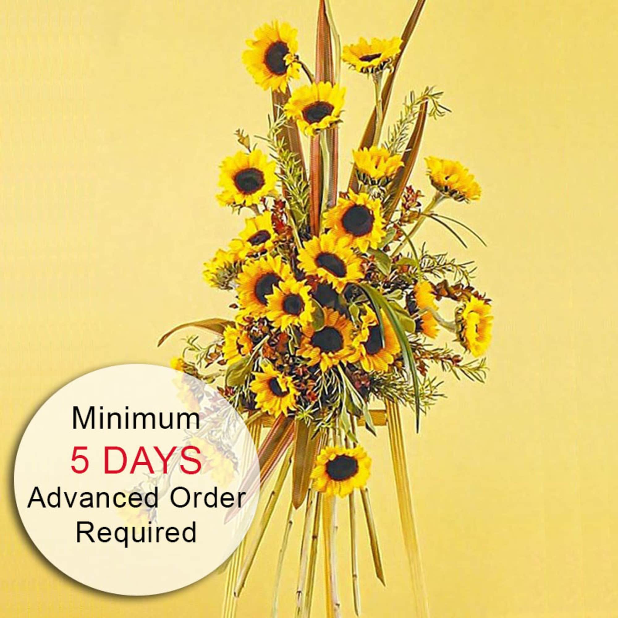 Tall standing arrangement of yellow sunflowers on a wooden tripod stand