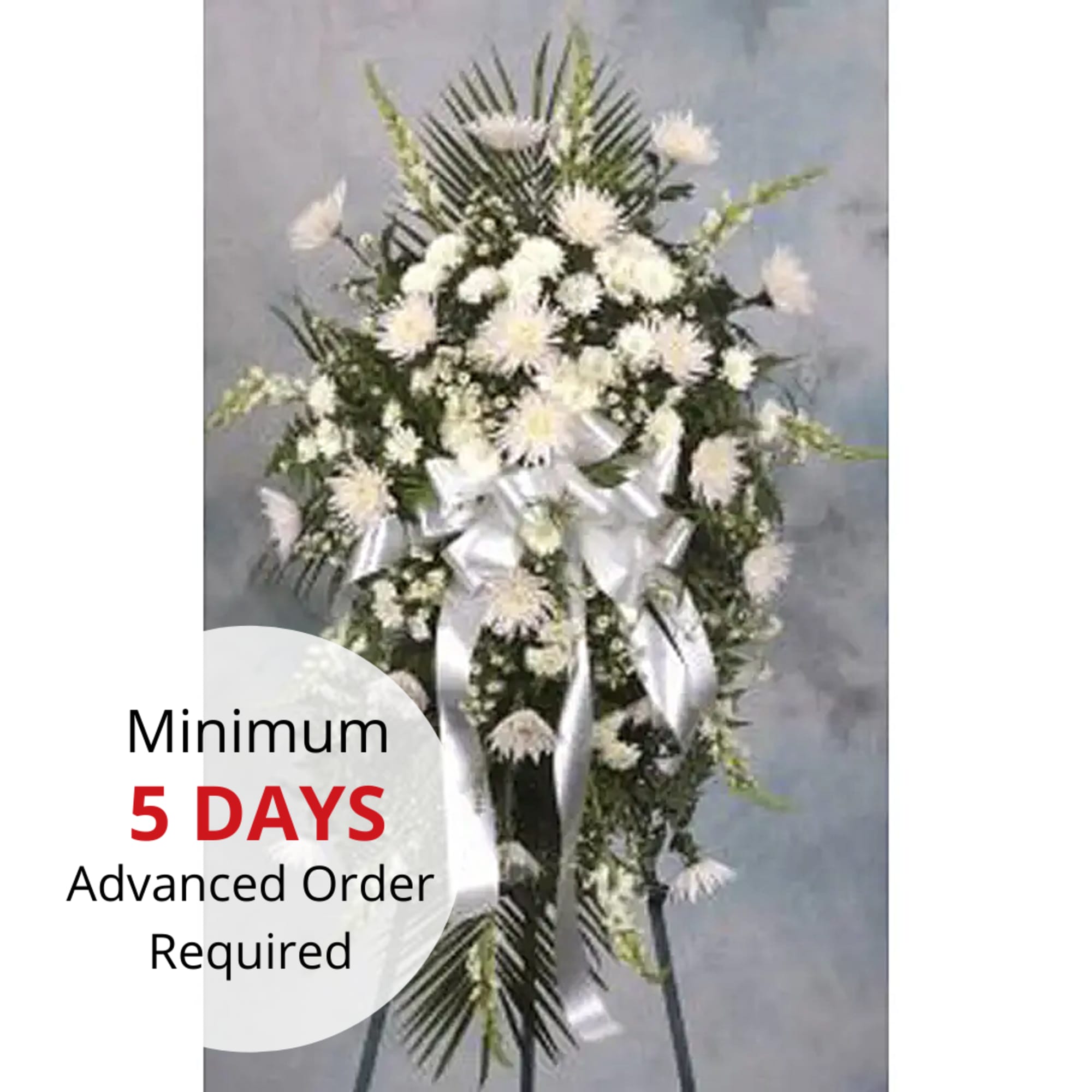 Tall white standing spray with chrysanthemums and silver ribbon on an easel stand