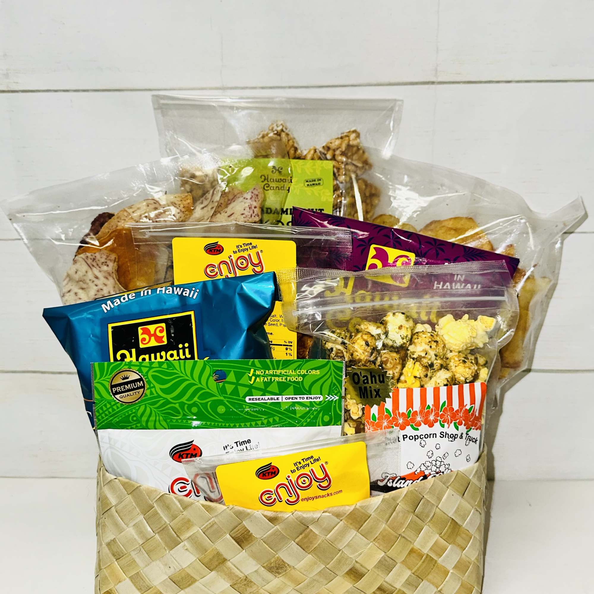 Gift basket filled with assorted Hawaiian snack bags and popcorn in a woven container