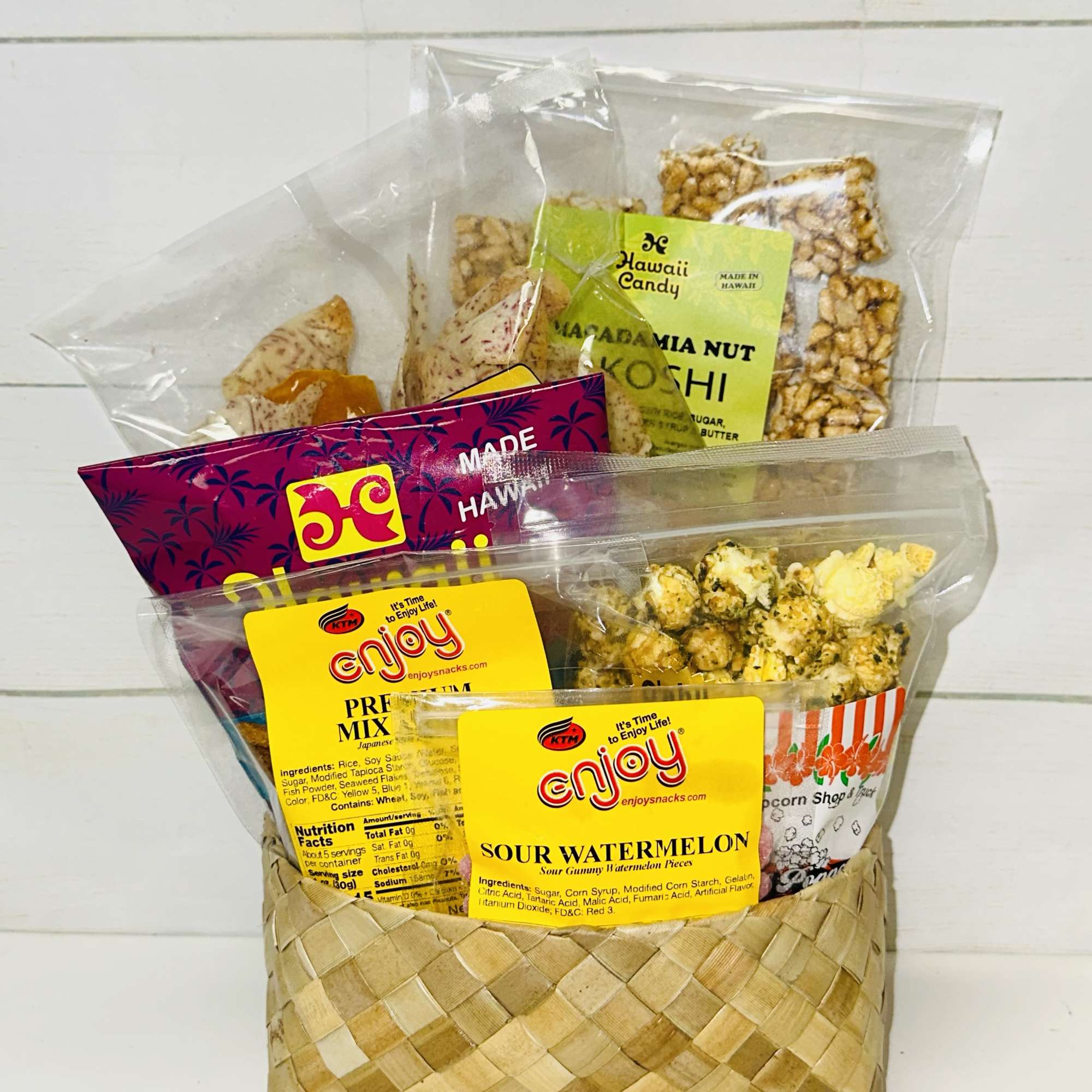 Woven gift basket filled with assorted packaged Hawaiian snacks and candies