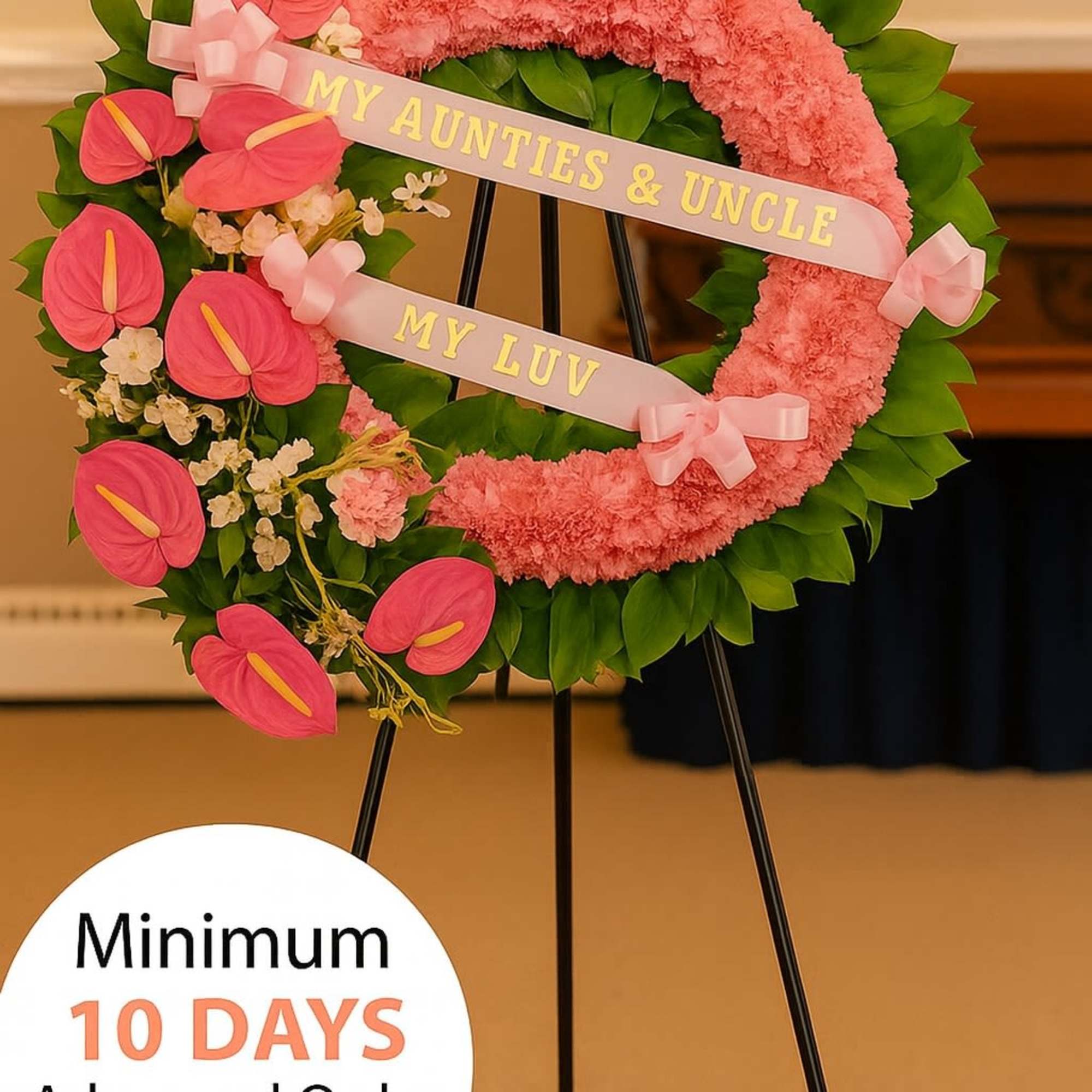 Pink floral wreath with ribbons on a metal stand for a memorial service