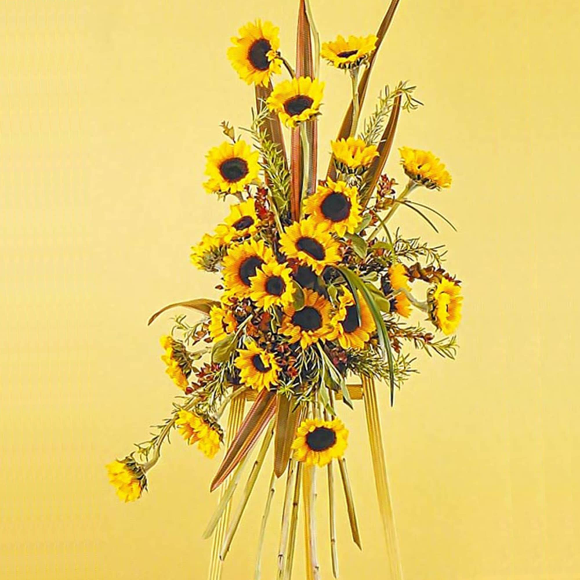 Tall standing arrangement of yellow sunflowers with linear accents on a bamboo easel.