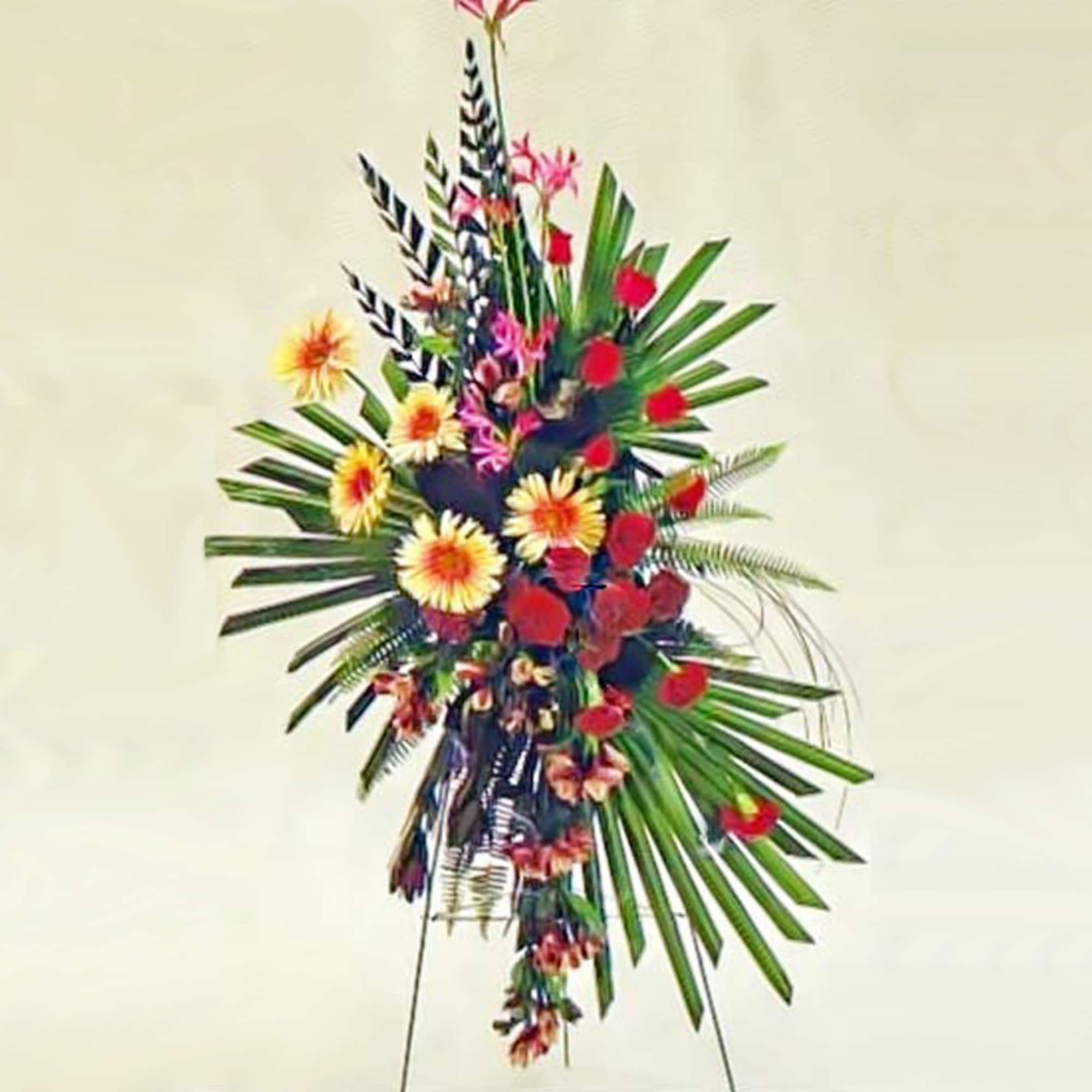 Tall standing spray with red and yellow flowers arranged among large green palm fronds