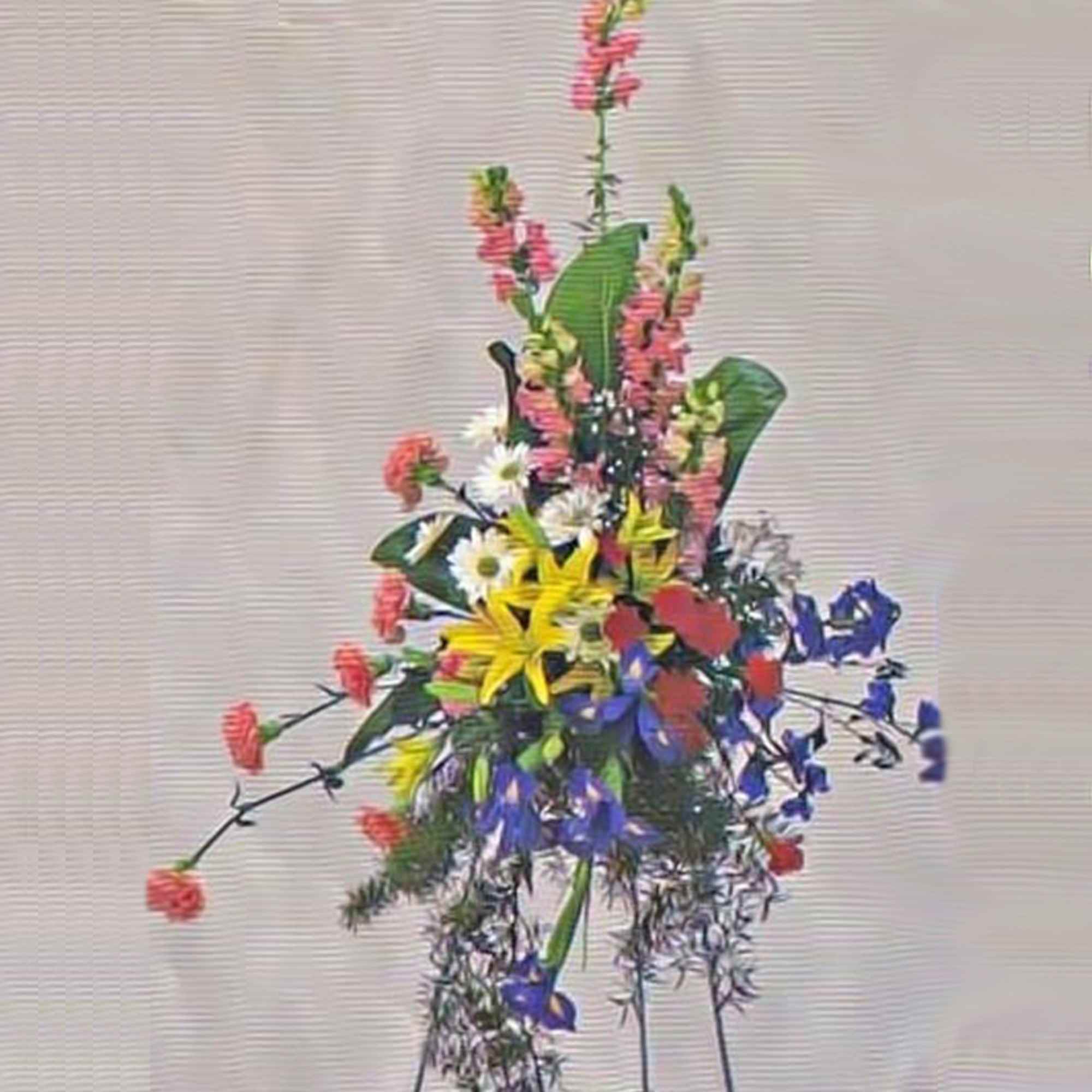 Tall standing spray of yellow lilies, white daisies, blue flowers, and pink accents on a metal easel.