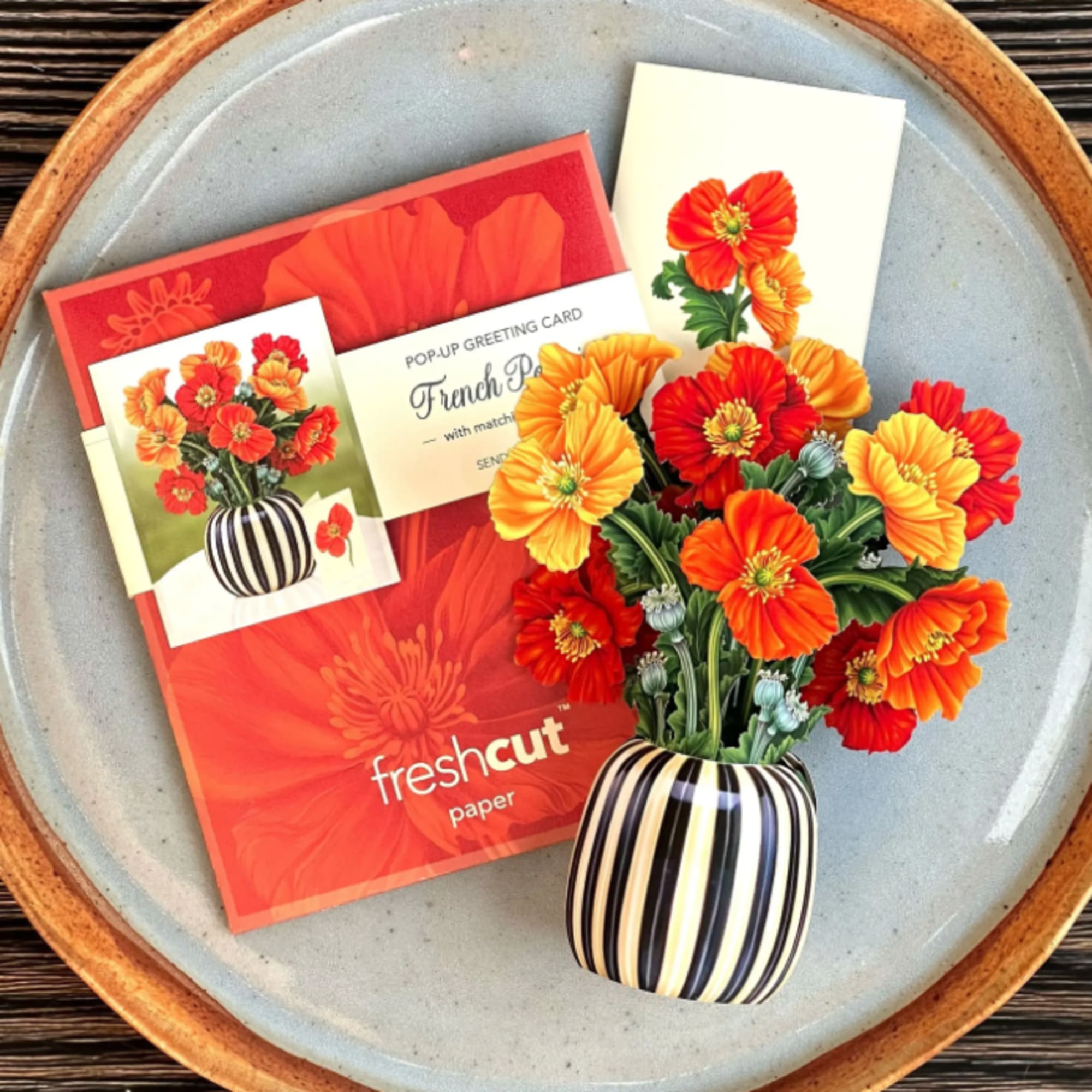 Pop-up greeting card with orange and red flowers in a striped vase
