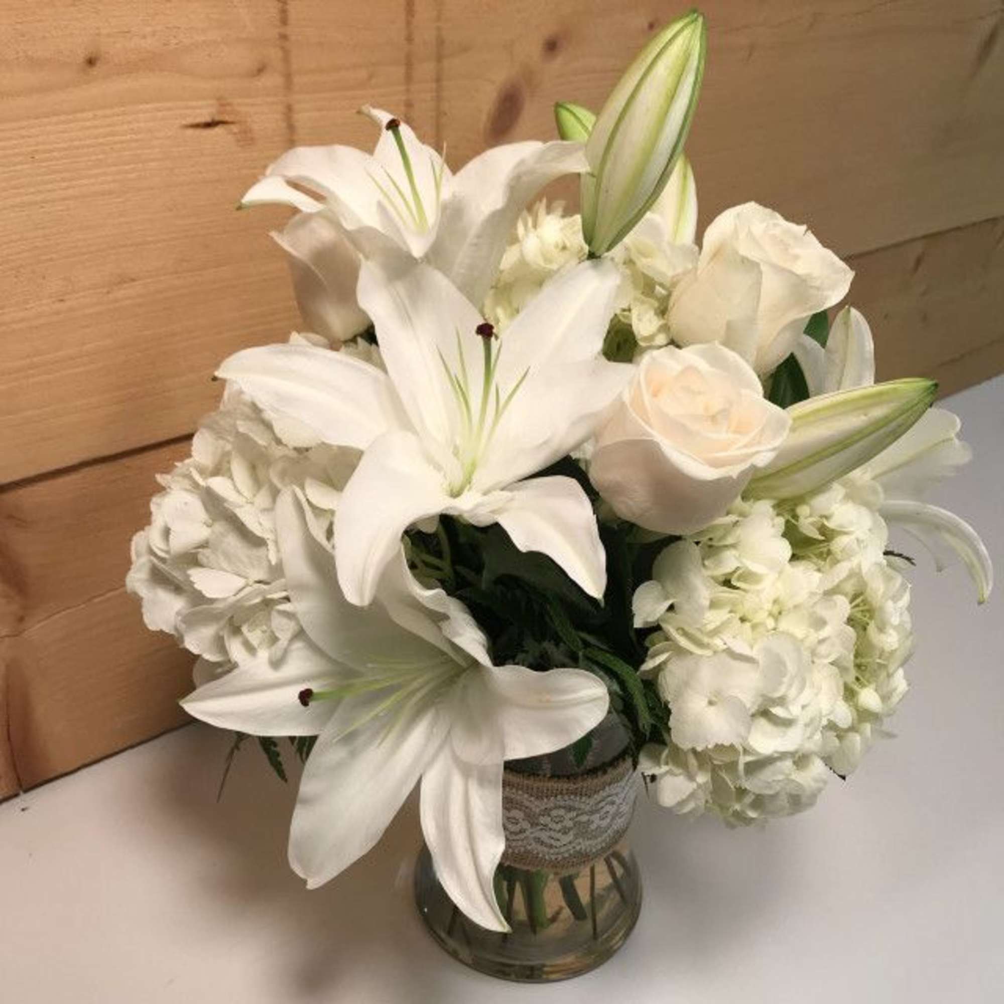 White lilies and roses arranged in a glass vase, photo 4 of 4