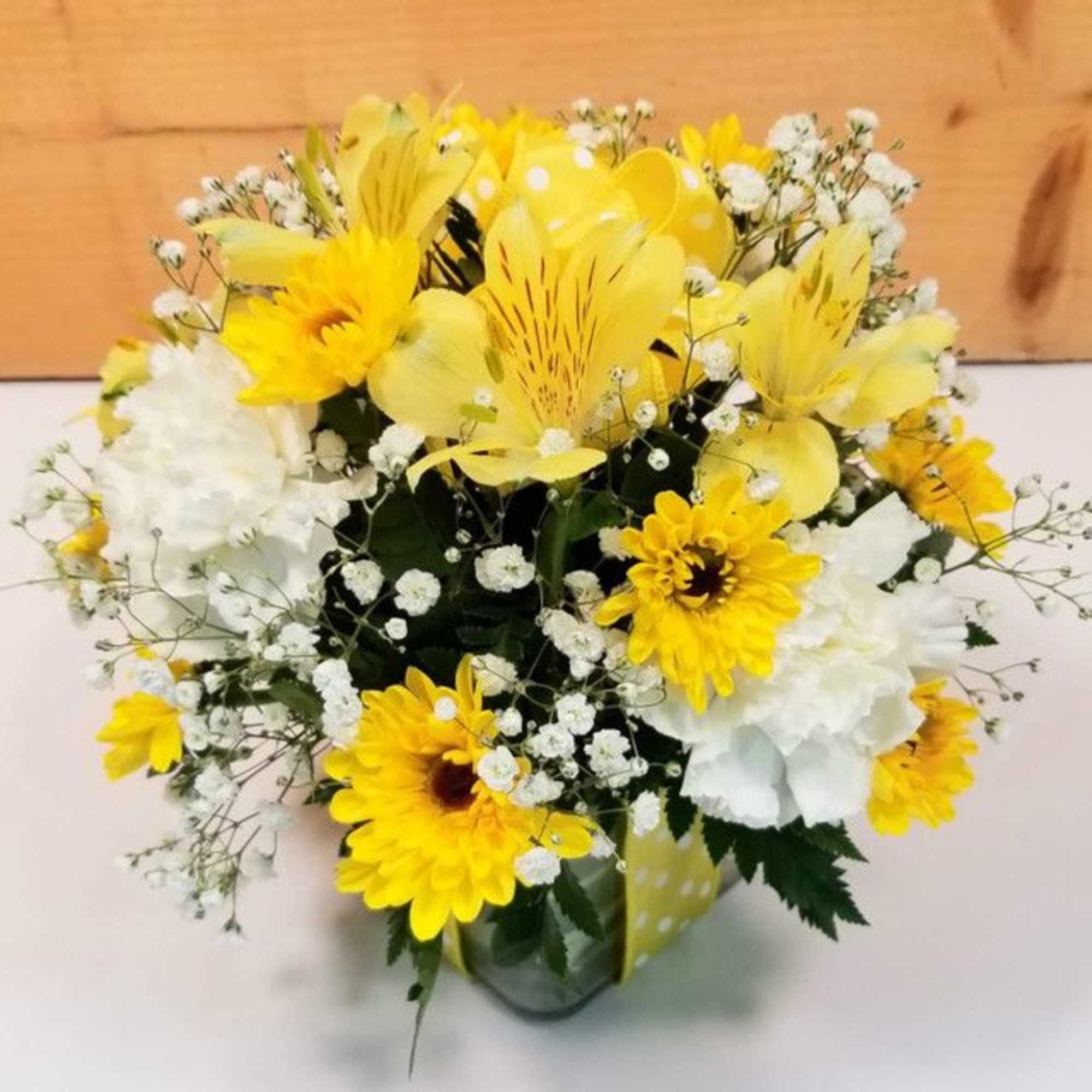 Yellow and white mixed flower bouquet in a glass vase