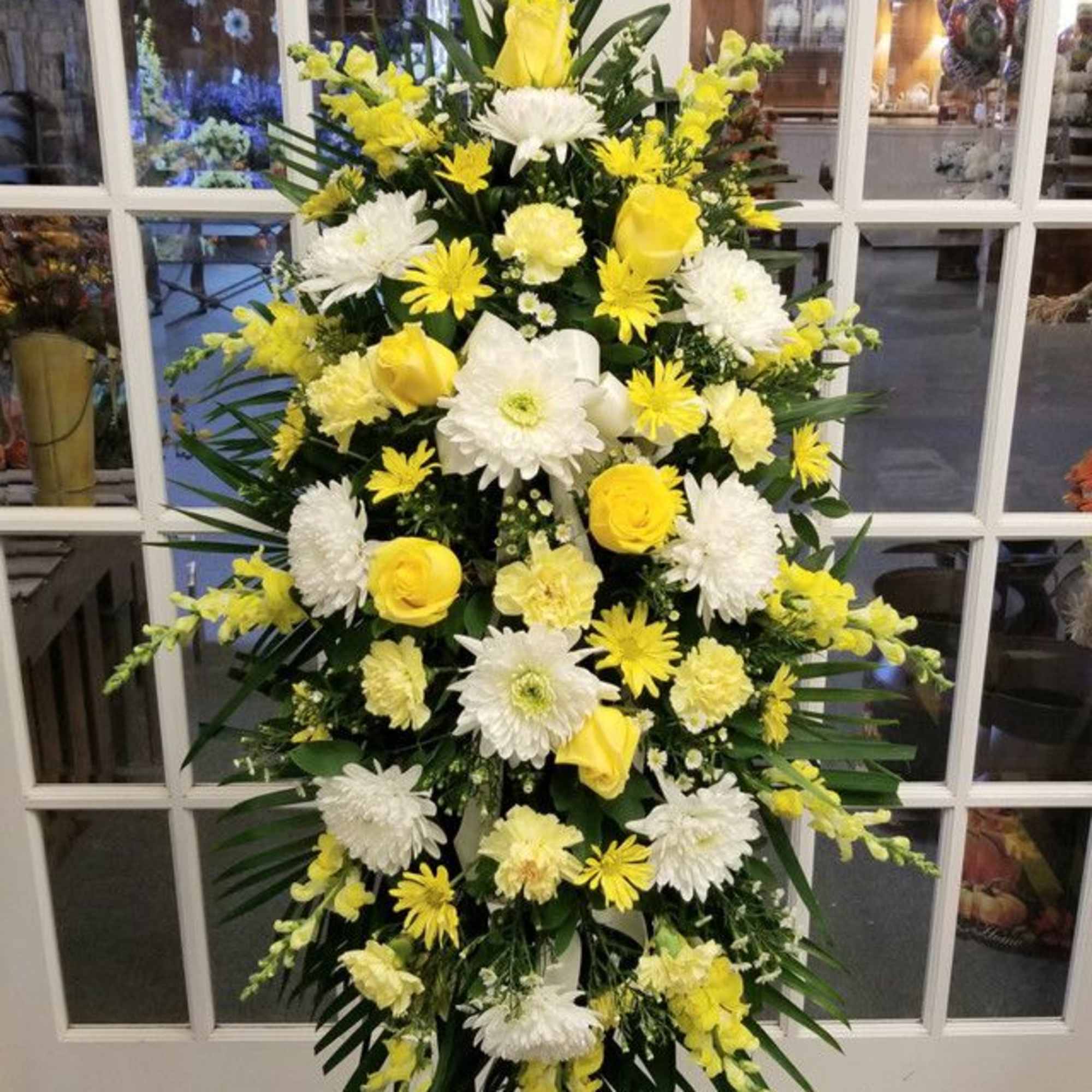 Yellow and white standing floral spray on an easel