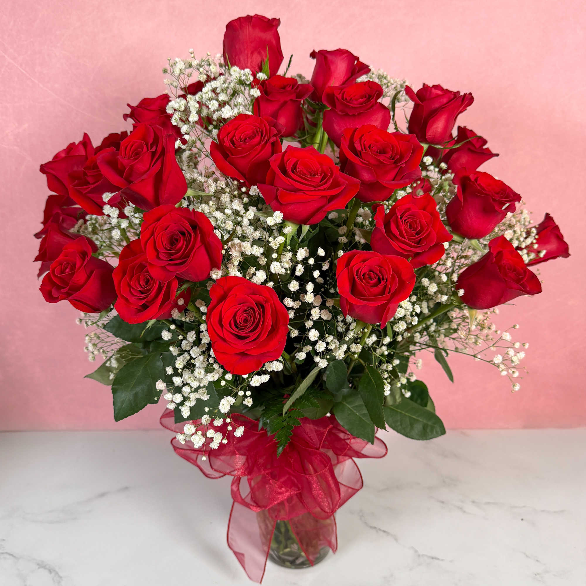 Bouquet of red roses with white baby's breath in a glass vase