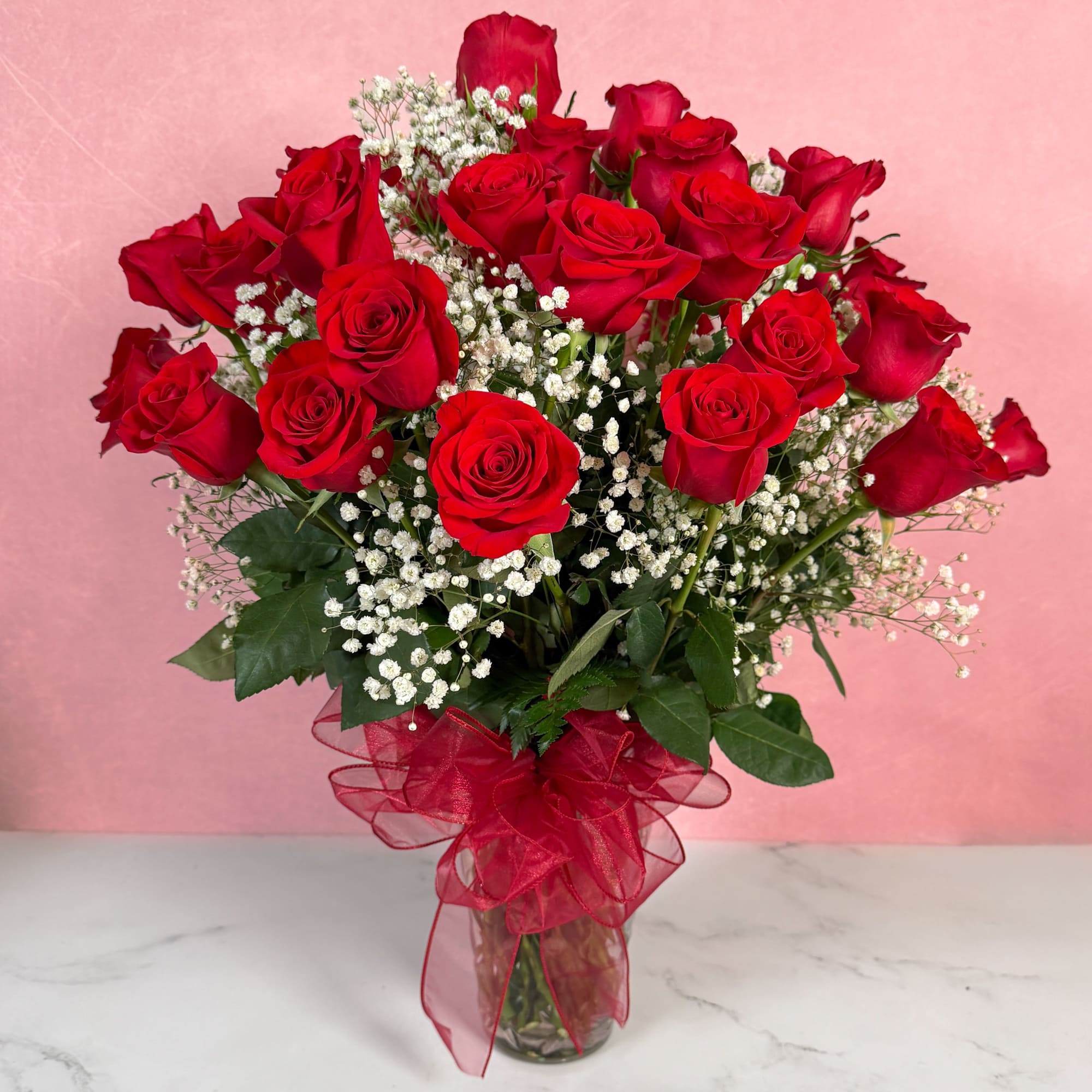 Bouquet of red roses with baby's breath in a glass vase
