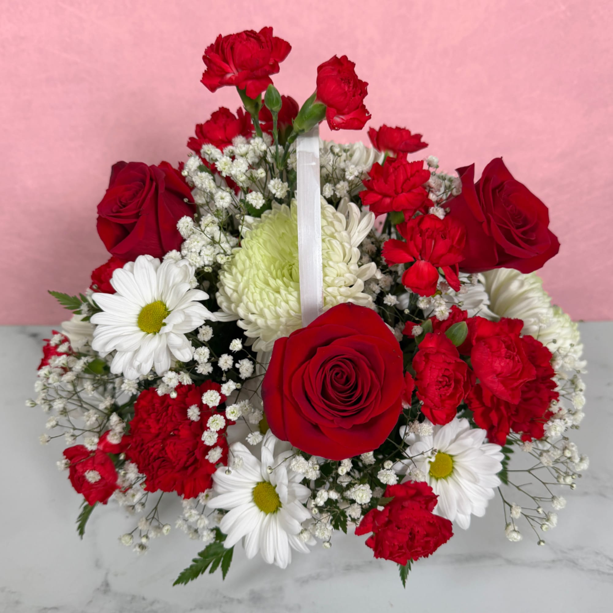 Red roses and white daisies in a hand-held bouquet