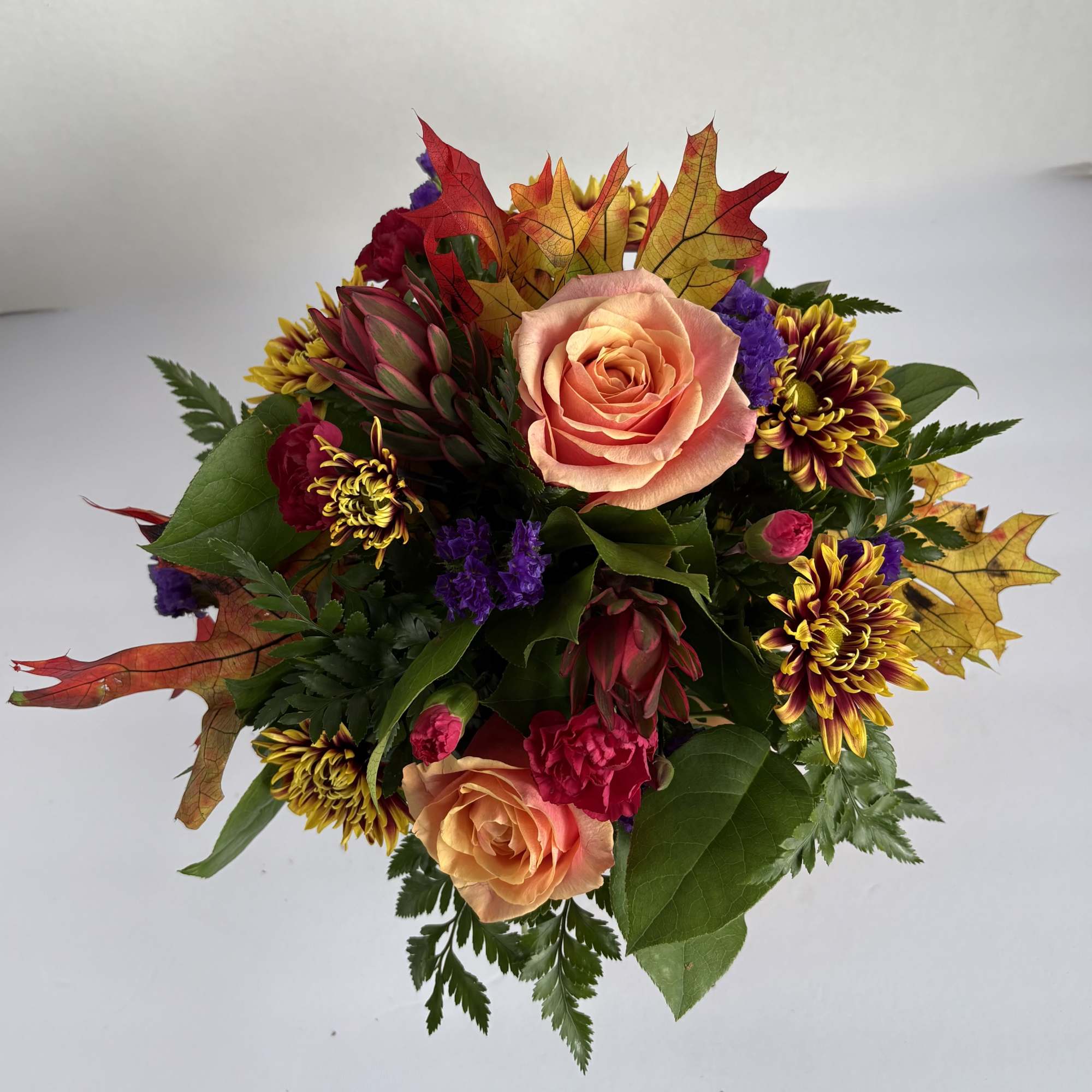 Bouquet of peach roses, chrysanthemums, and autumn leaves