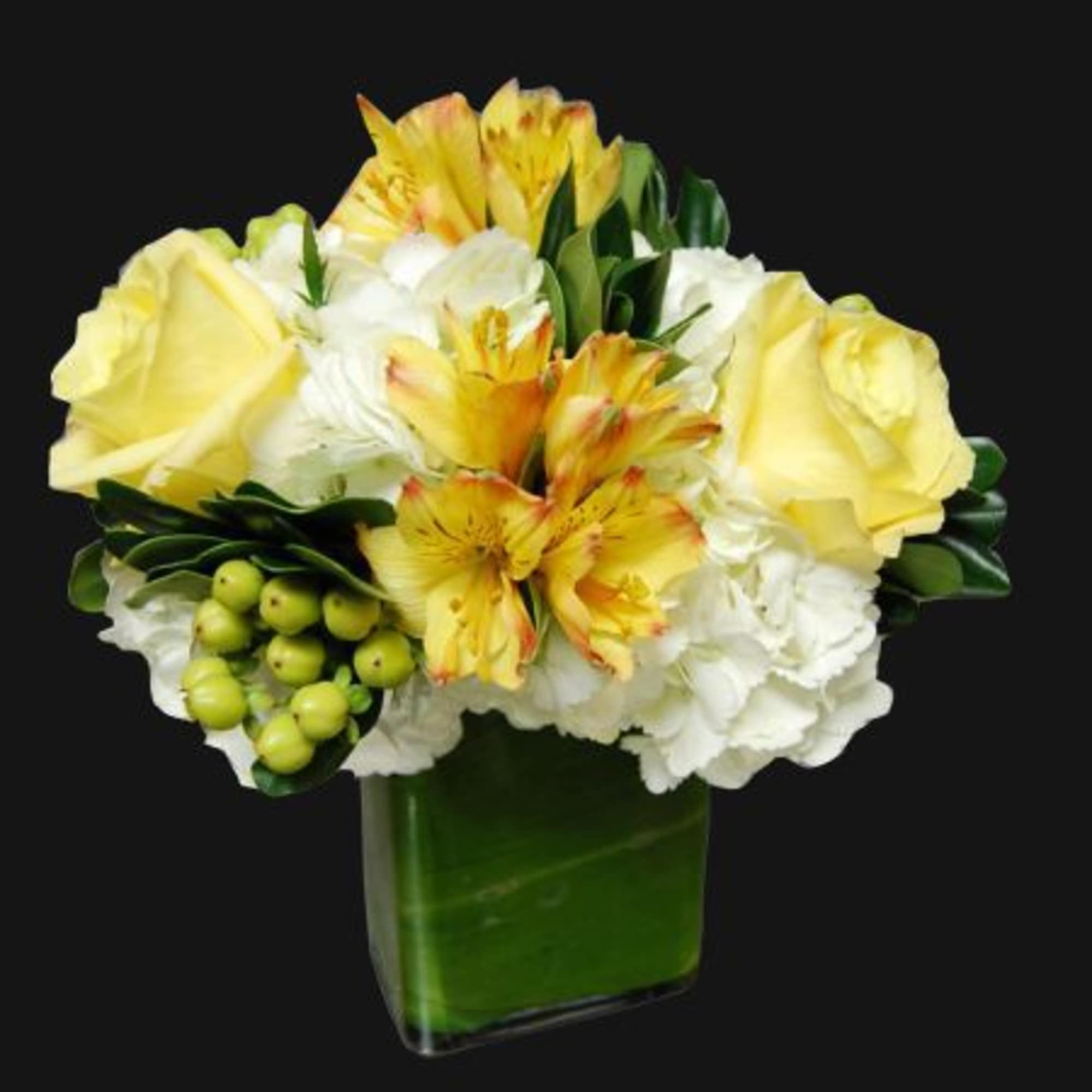 Yellow roses and white flowers in a green glass vase