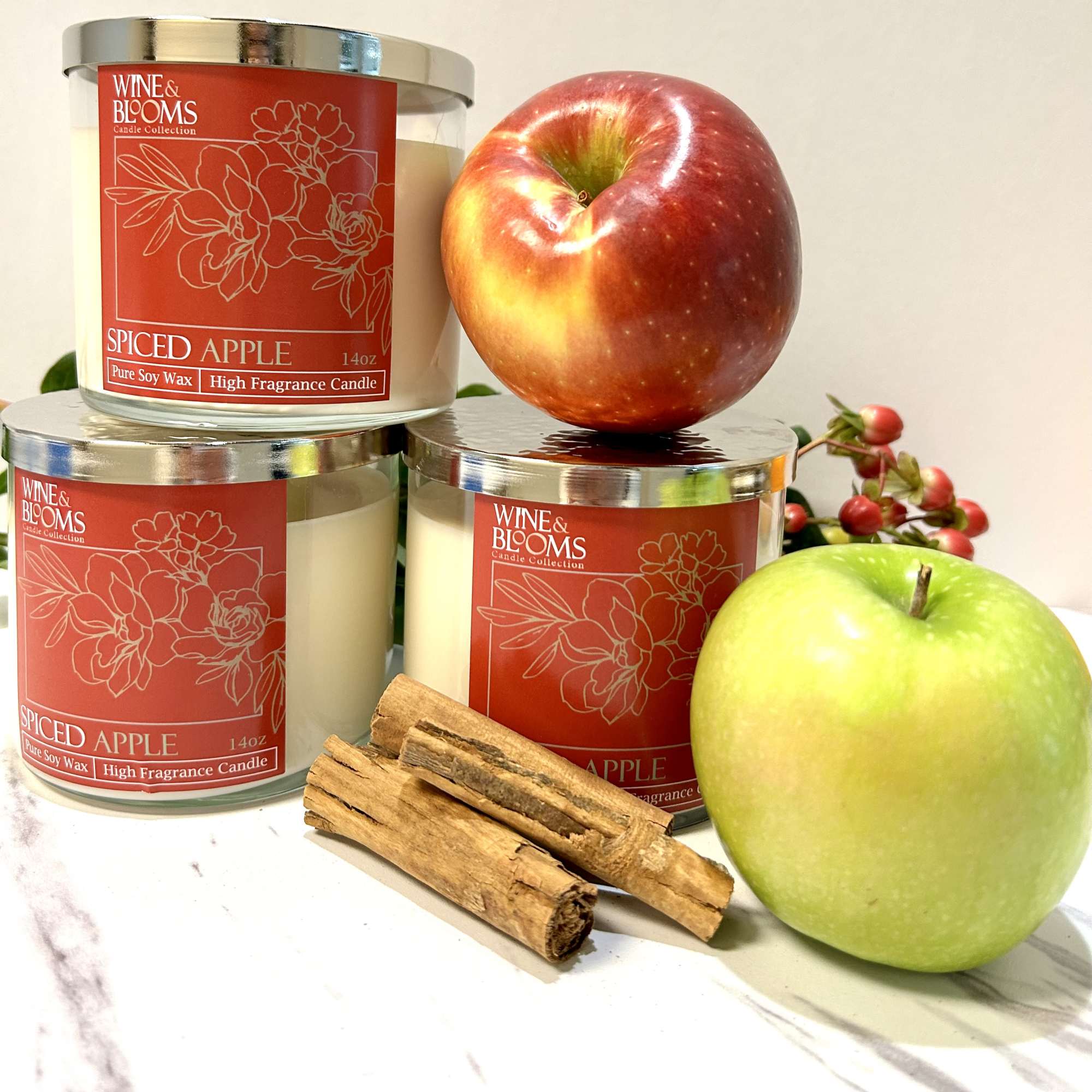 Three spiced apple candles with apples and cinnamon sticks
