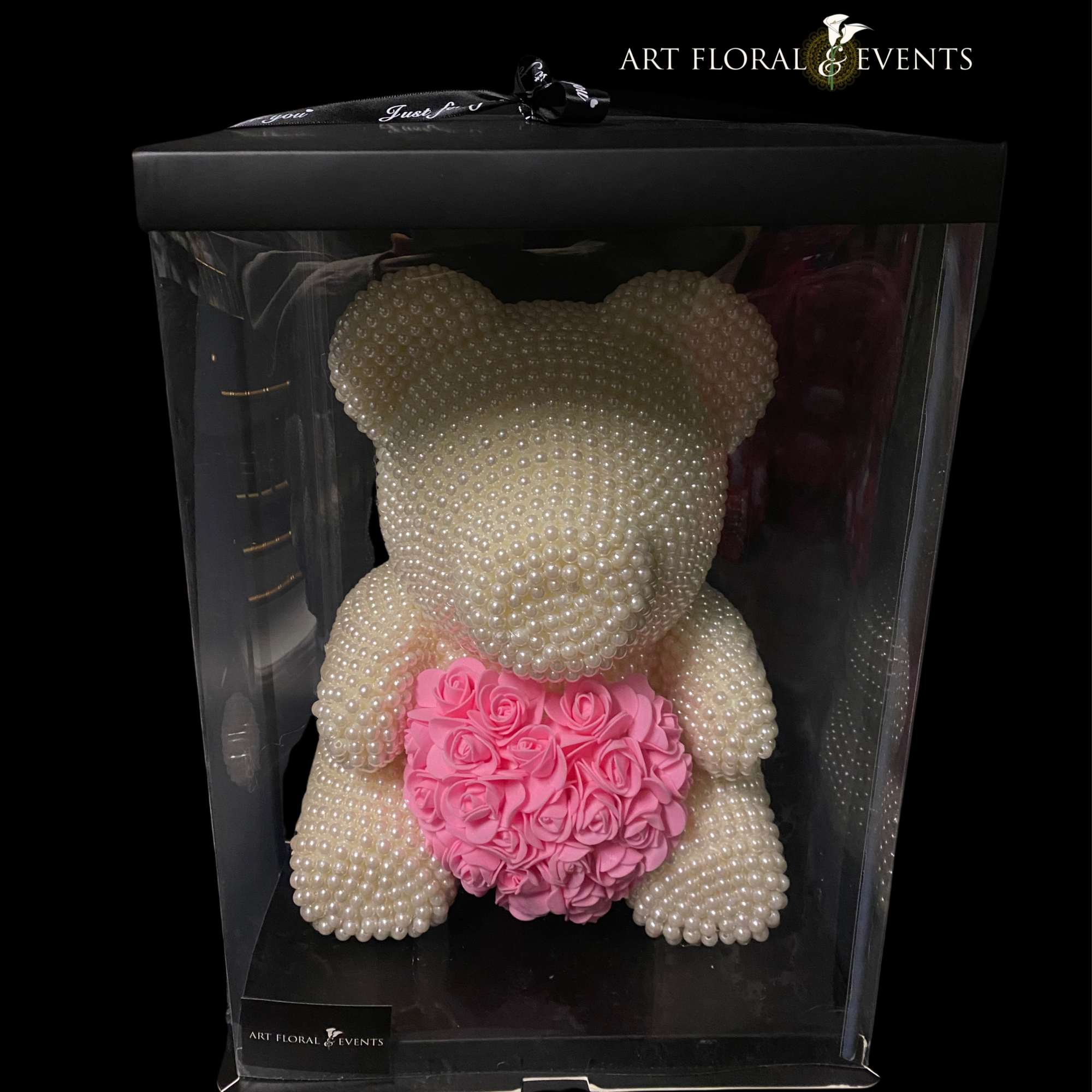 Pearl teddy bear holding a pink rose heart in a clear gift box