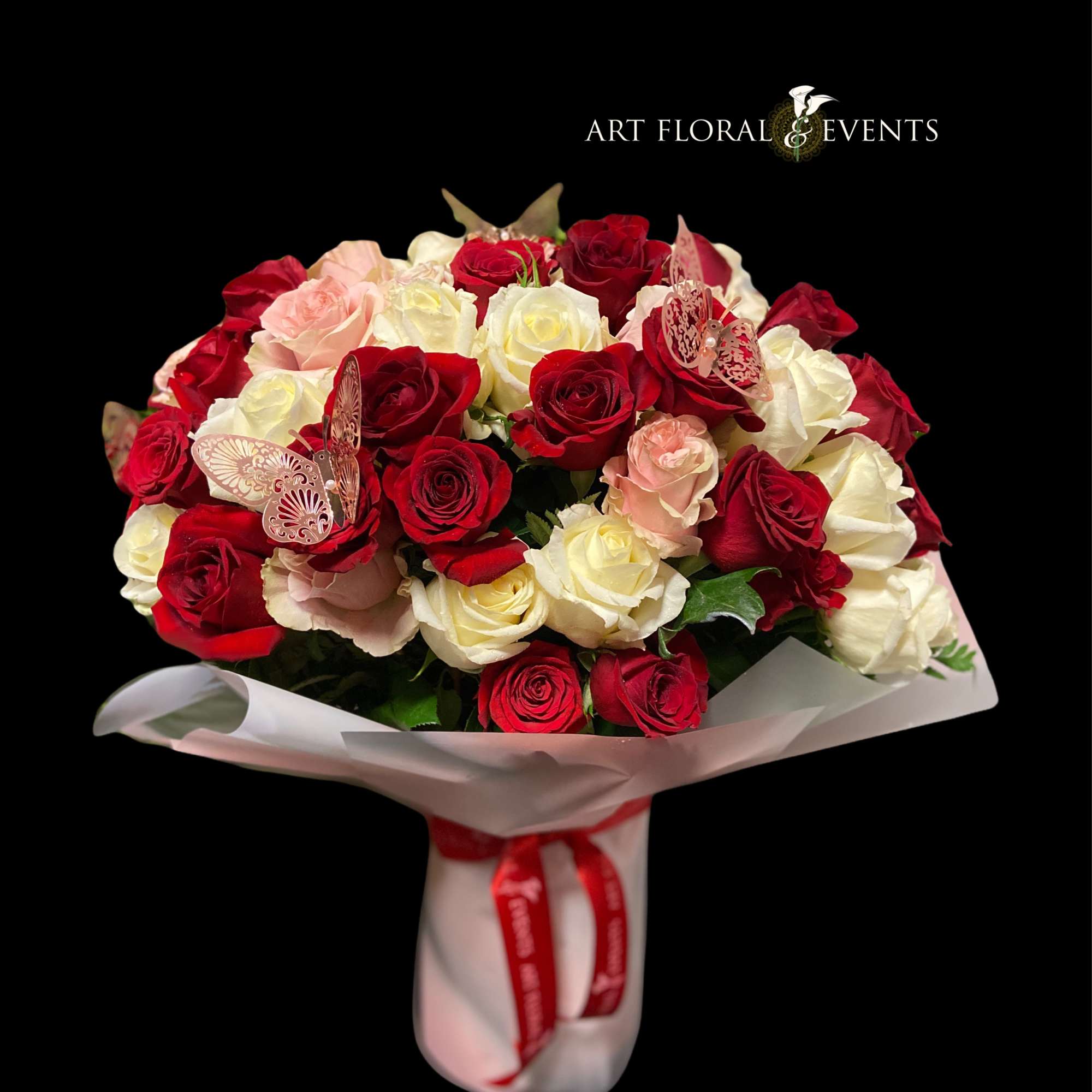 Bouquet of red, white, and blush roses wrapped in white paper