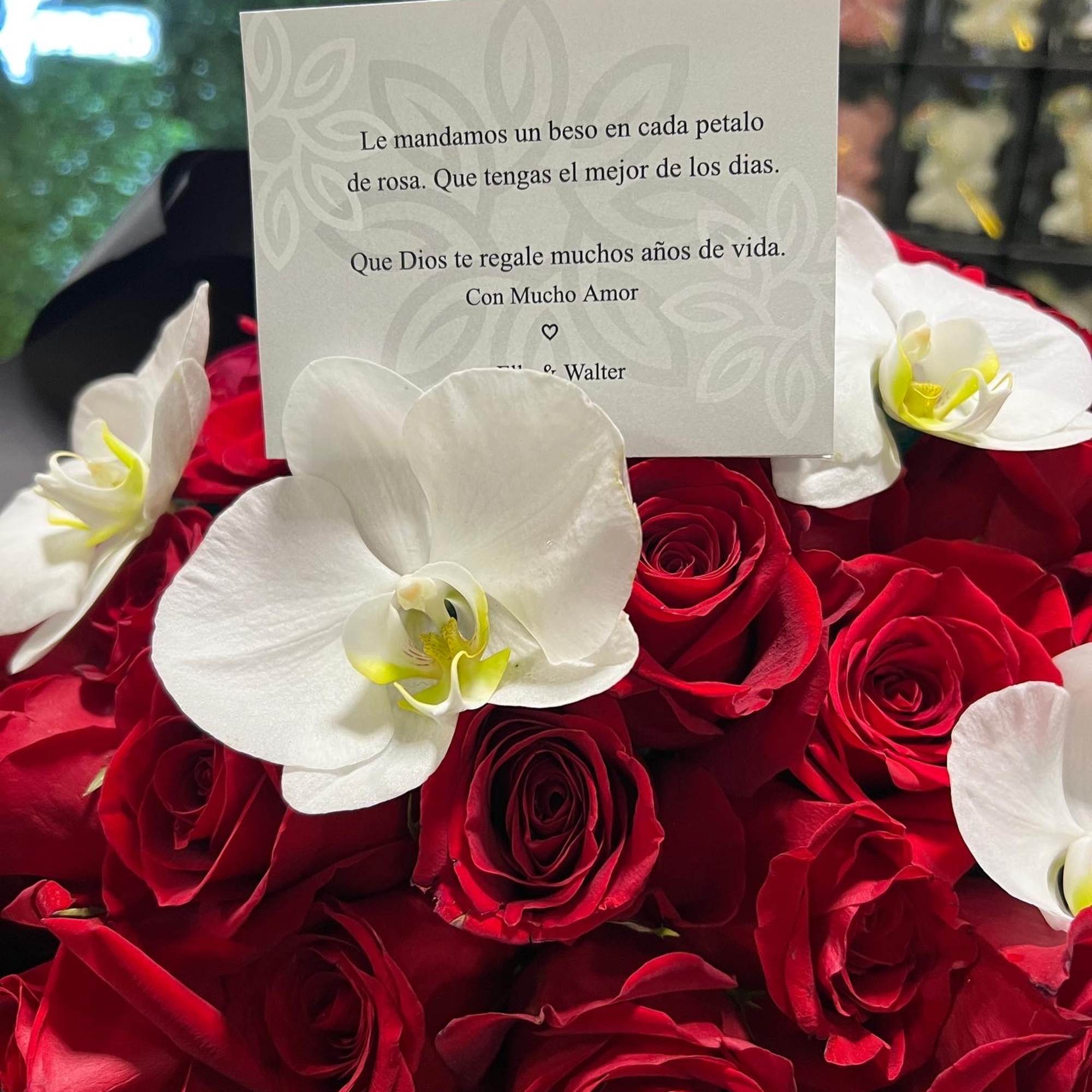 Red roses with white orchids and a greeting card