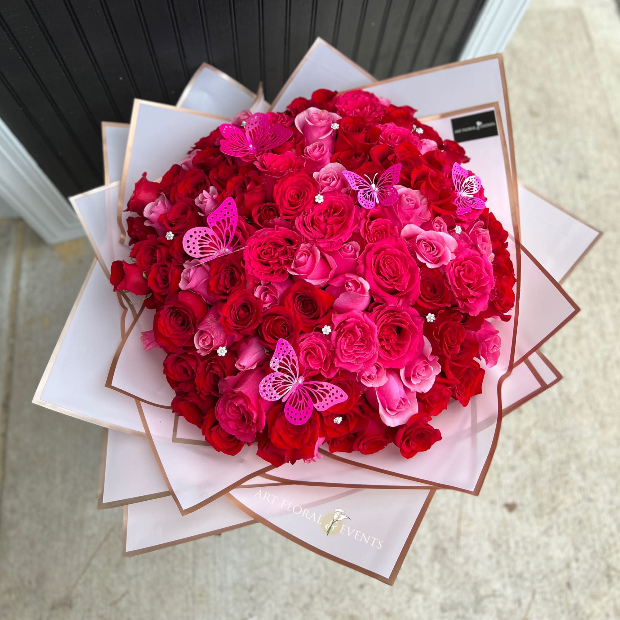 Large bouquet of red and pink roses with butterfly picks