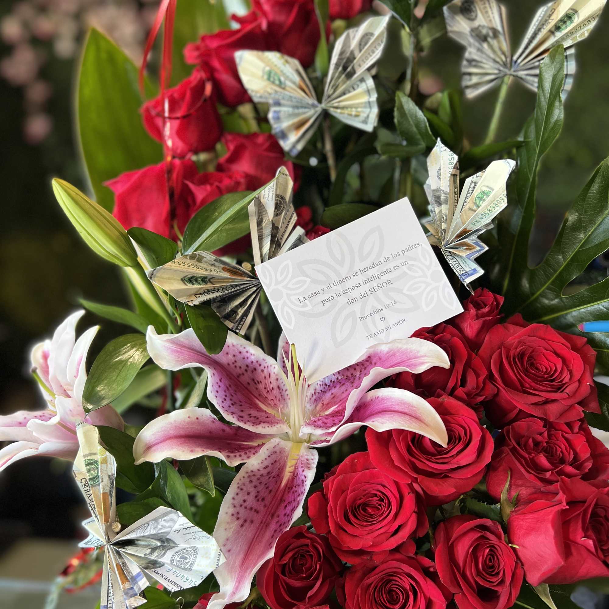 Red roses and pink lilies with folded dollar-bill butterflies