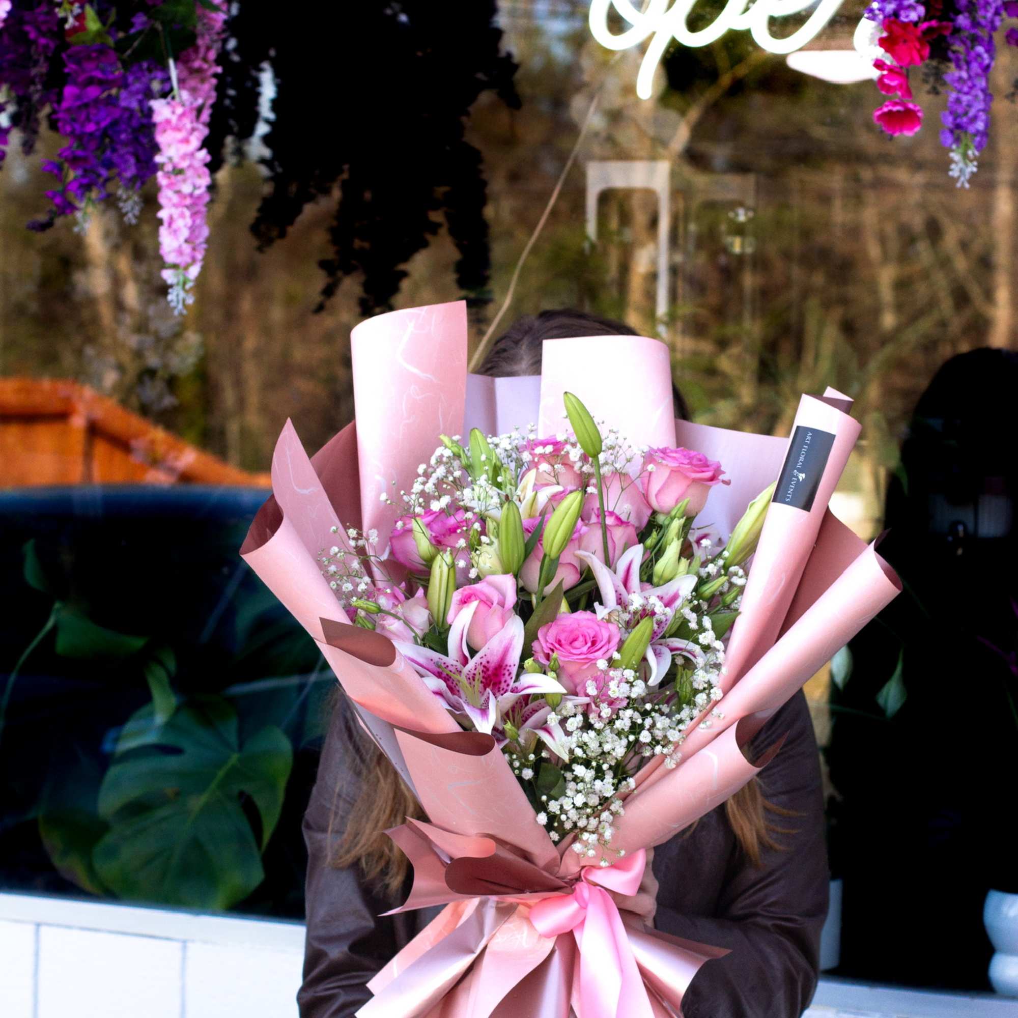 Pink bouquet with lilies and roses wrapped in pastel paper