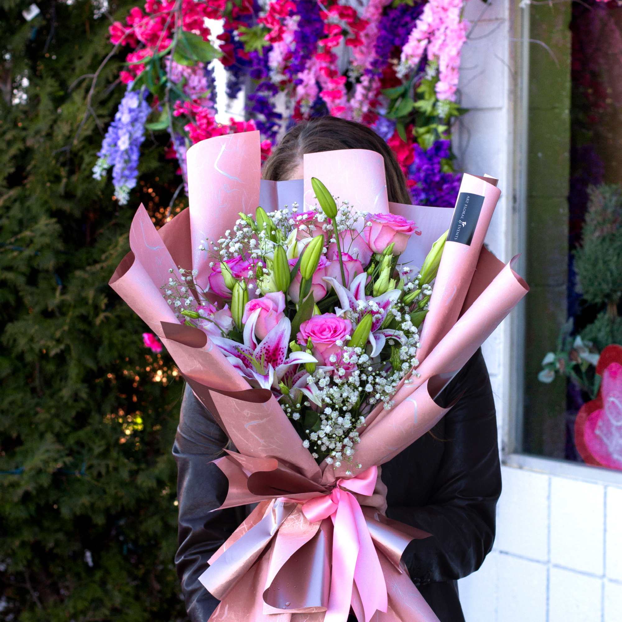 Large bouquet of pink roses and lilies wrapped in pink paper