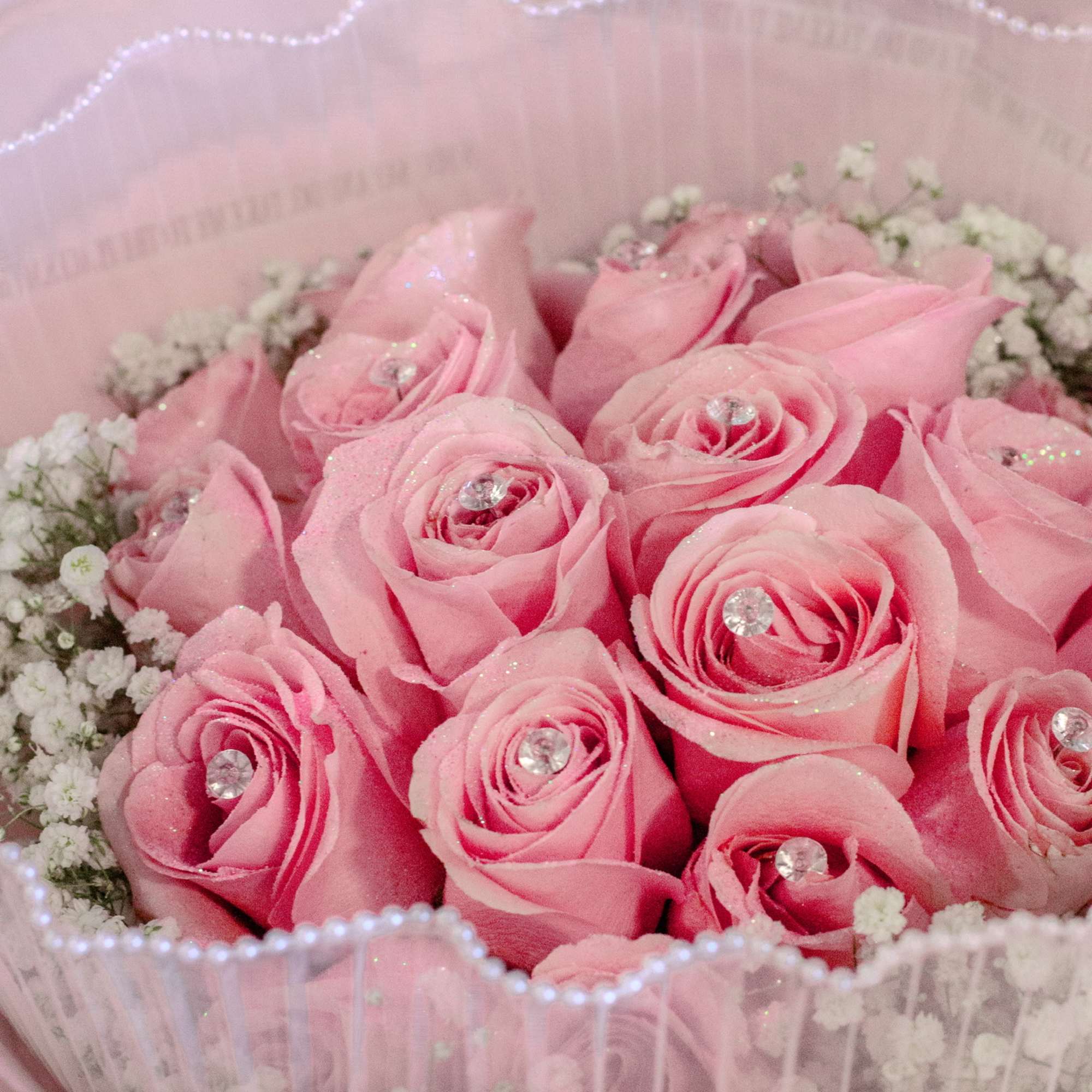Pink rose bouquet with baby's breath in pale pink wrapping