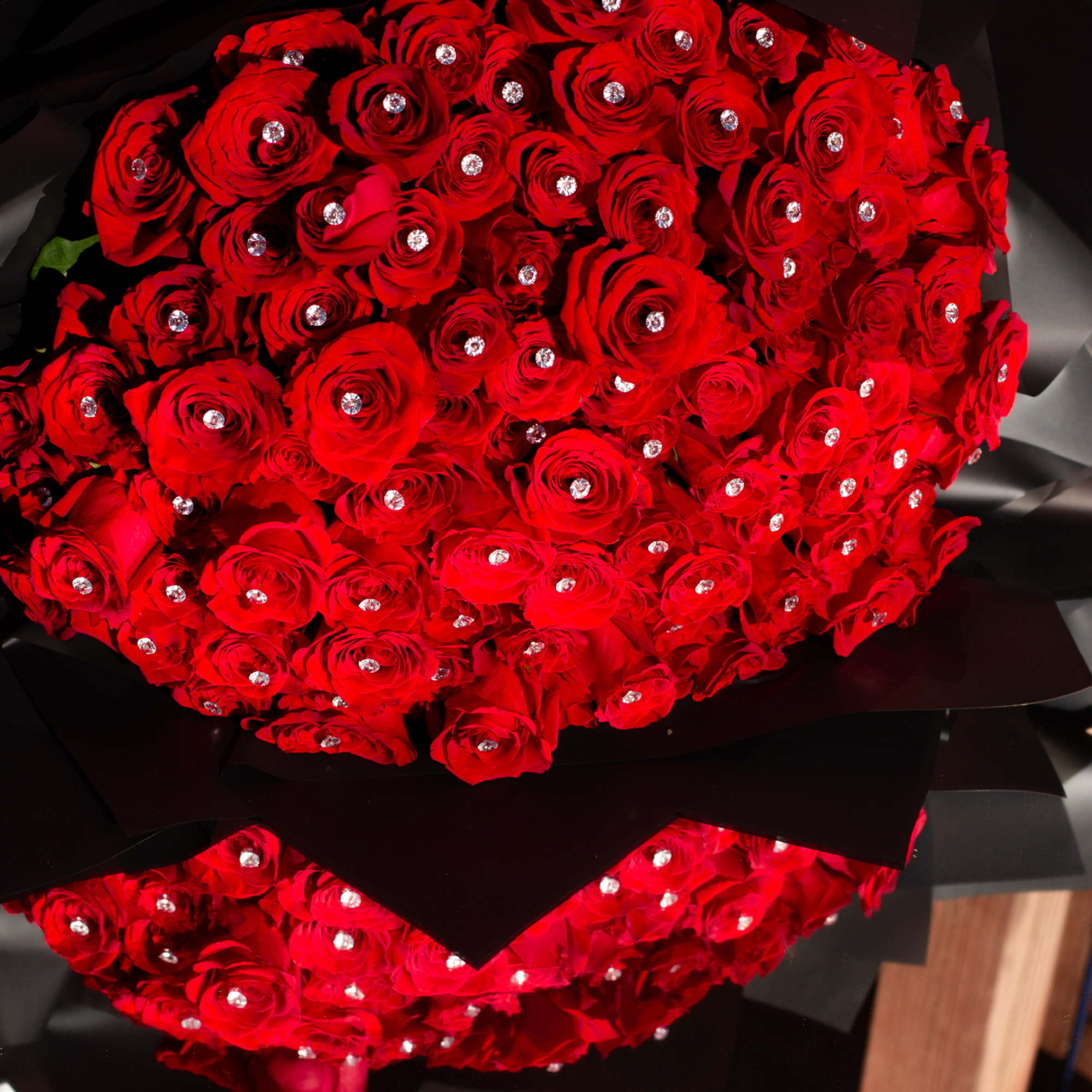 Large bouquet of red roses wrapped in black paper