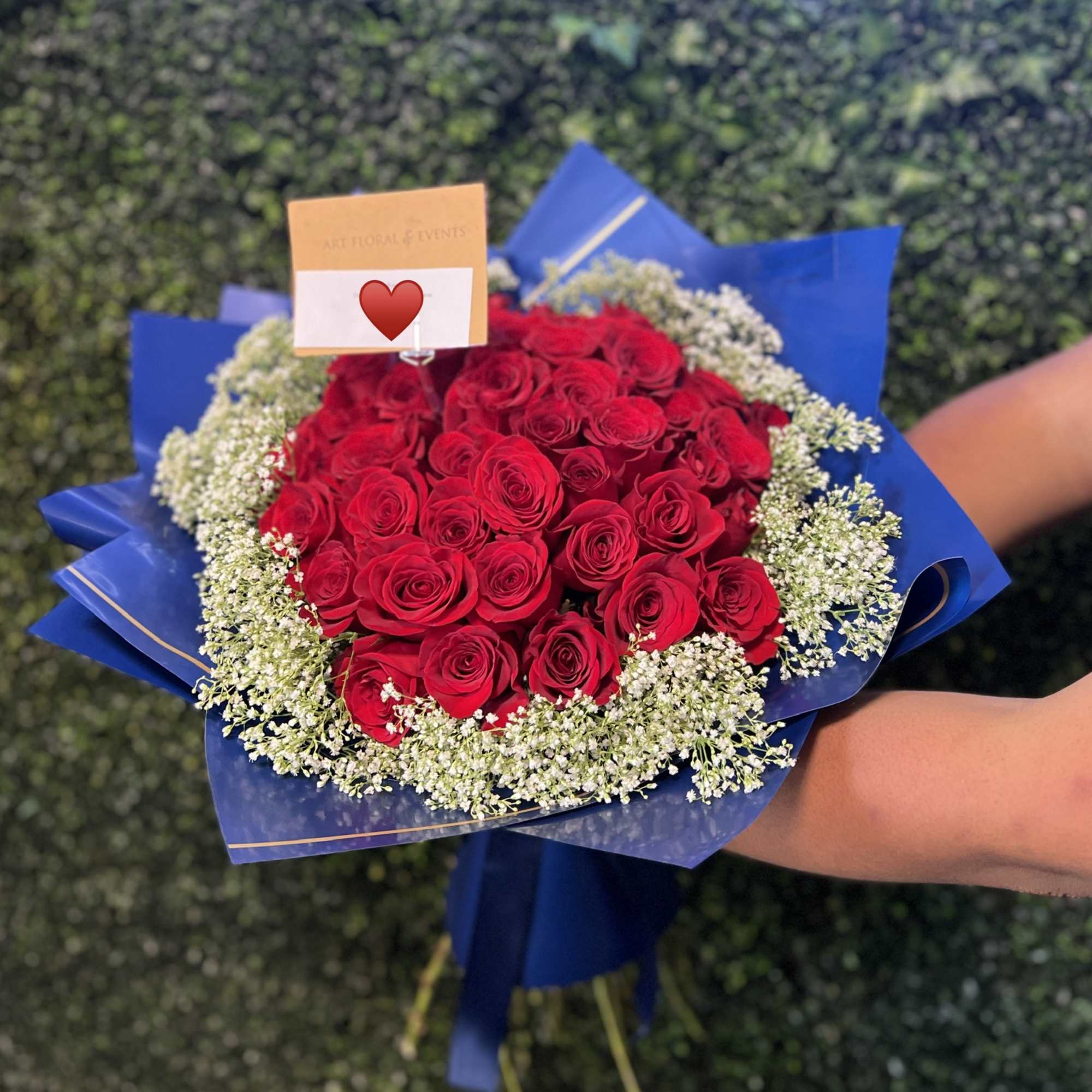 Bouquet of red roses wrapped in blue paper