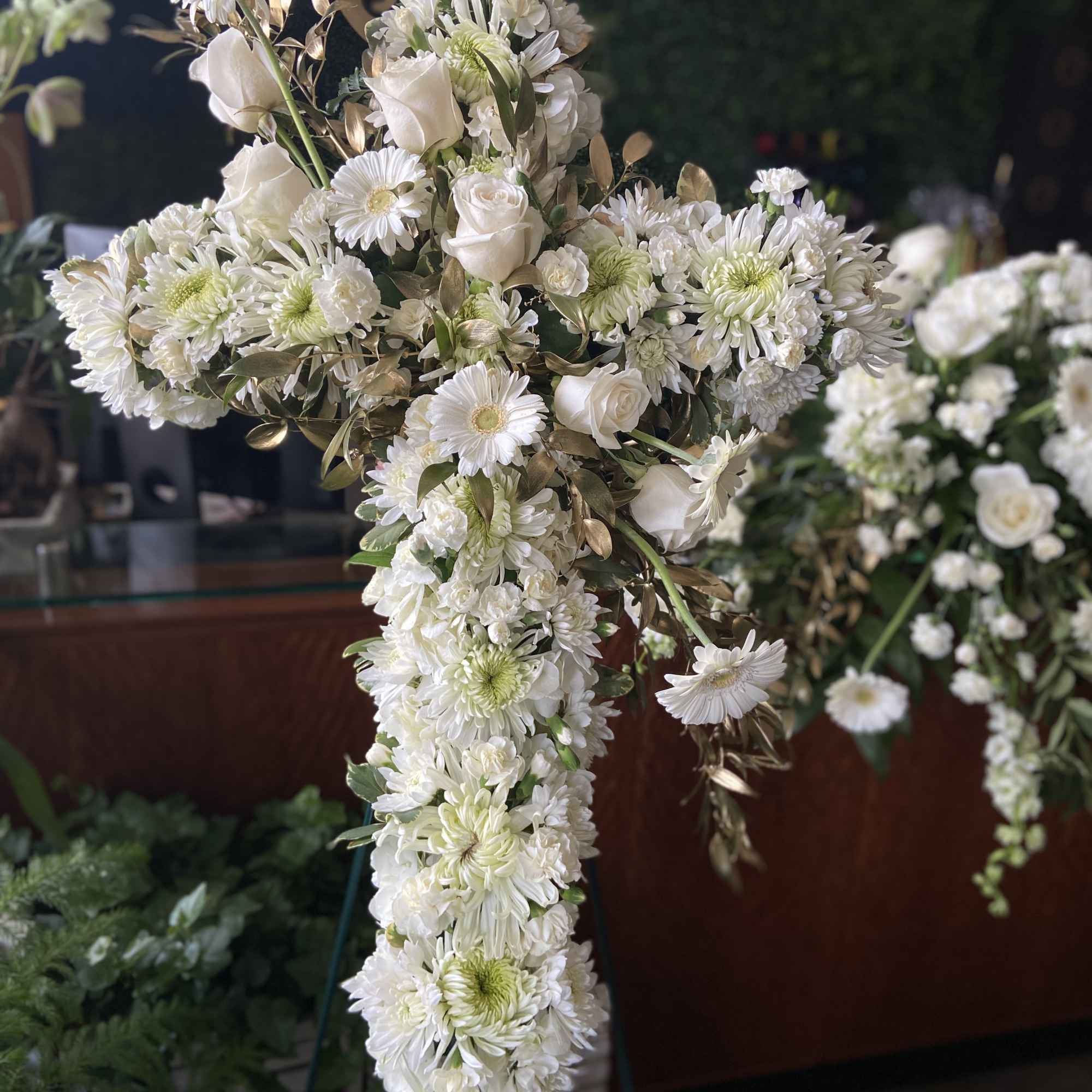 White floral cross arrangement with daisies and roses