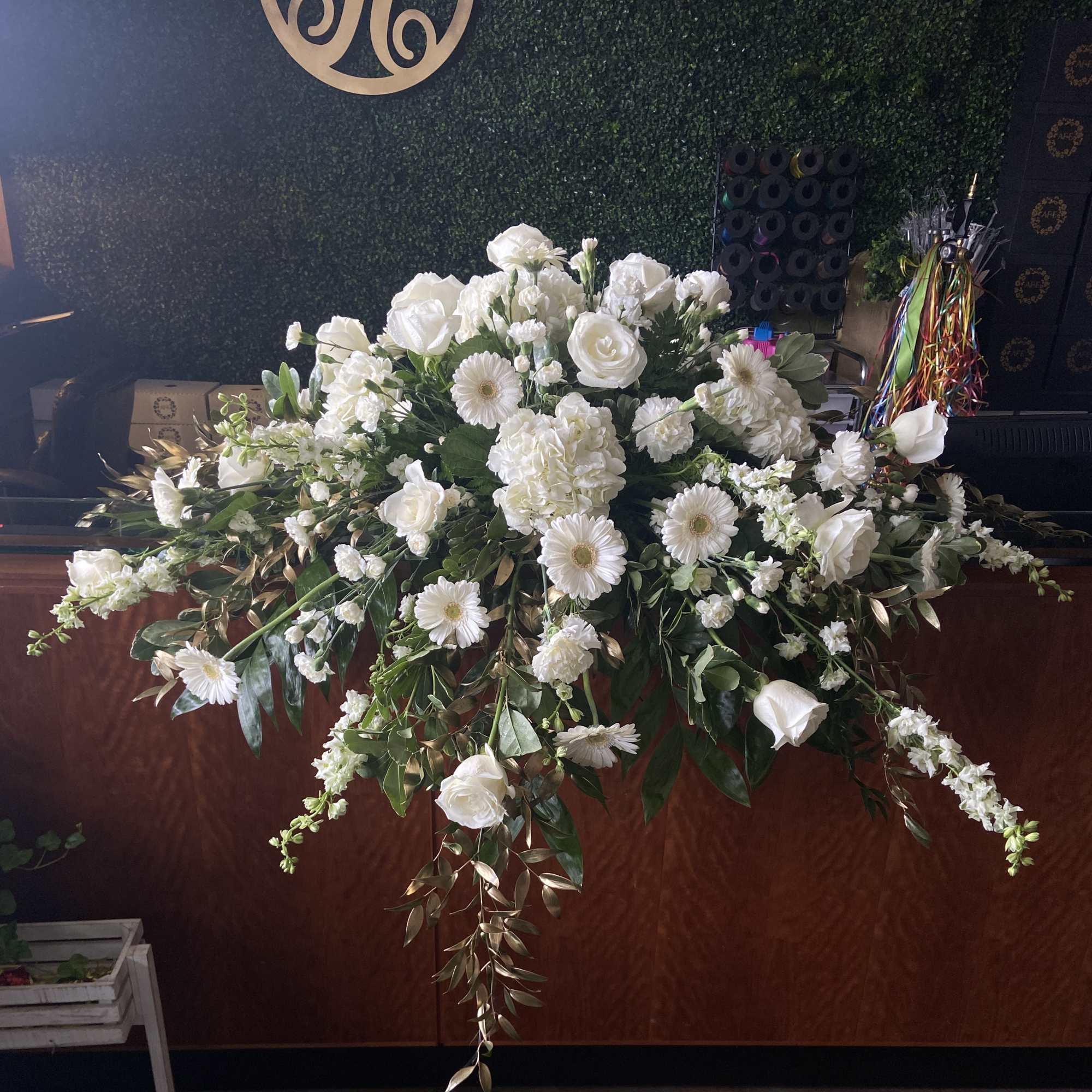 Large white floral arrangement with roses and daisies on a counter