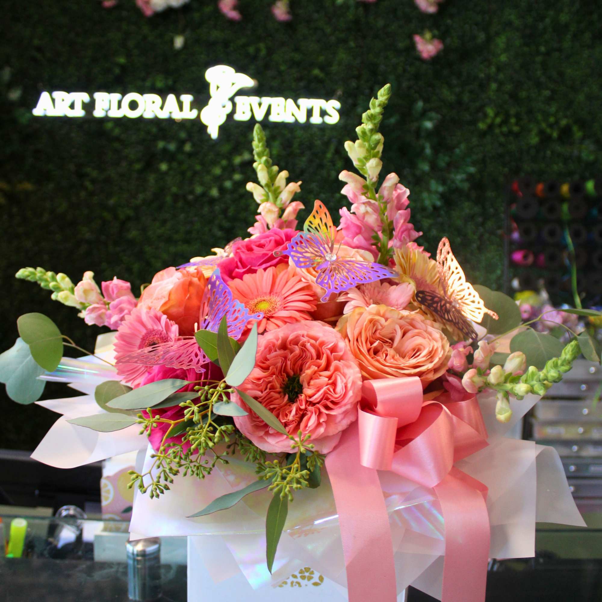 Pink and peach bouquet with roses, gerbera daisies, and a ribbon in a white box
