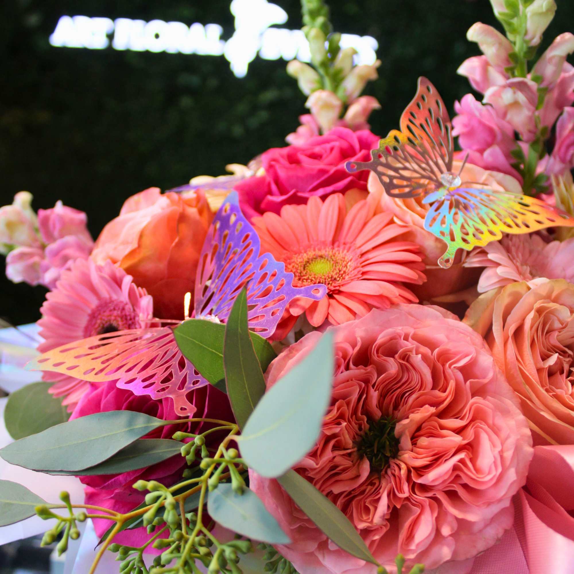 Pink and peach bouquet with butterflies and eucalyptus