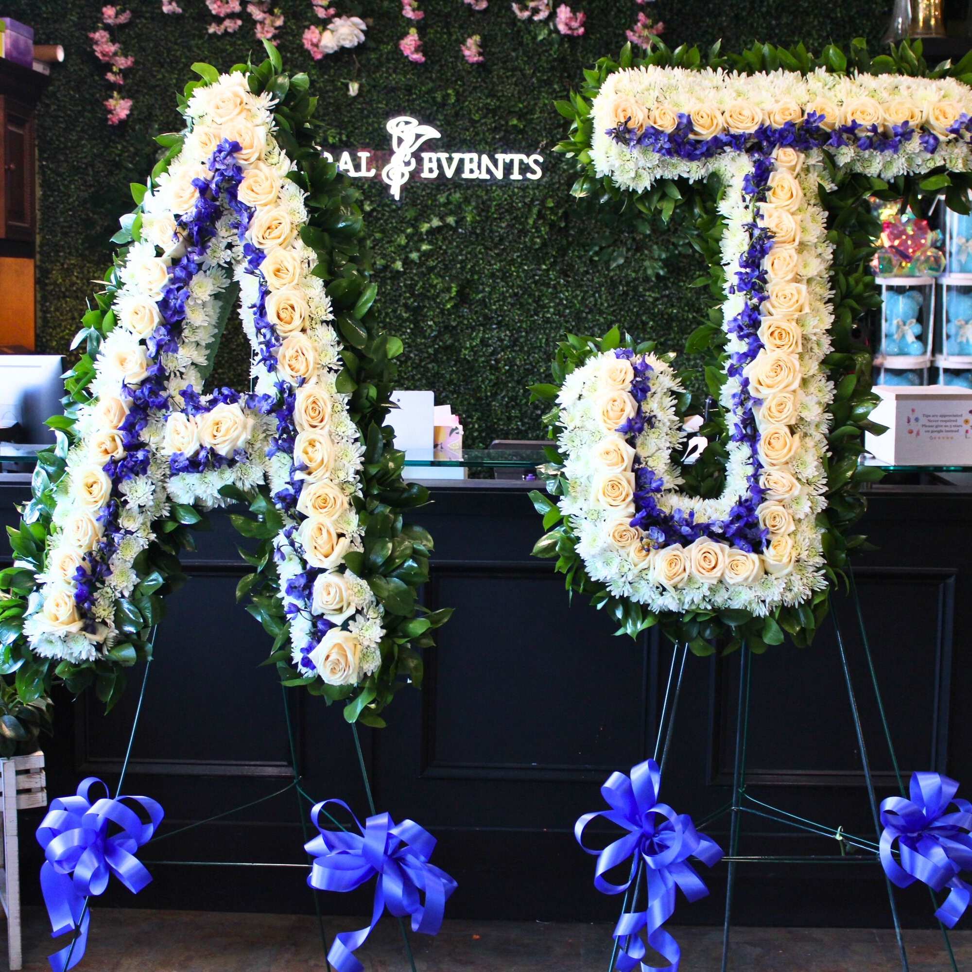 Large floral letter A and U on stands with cream and purple flowers