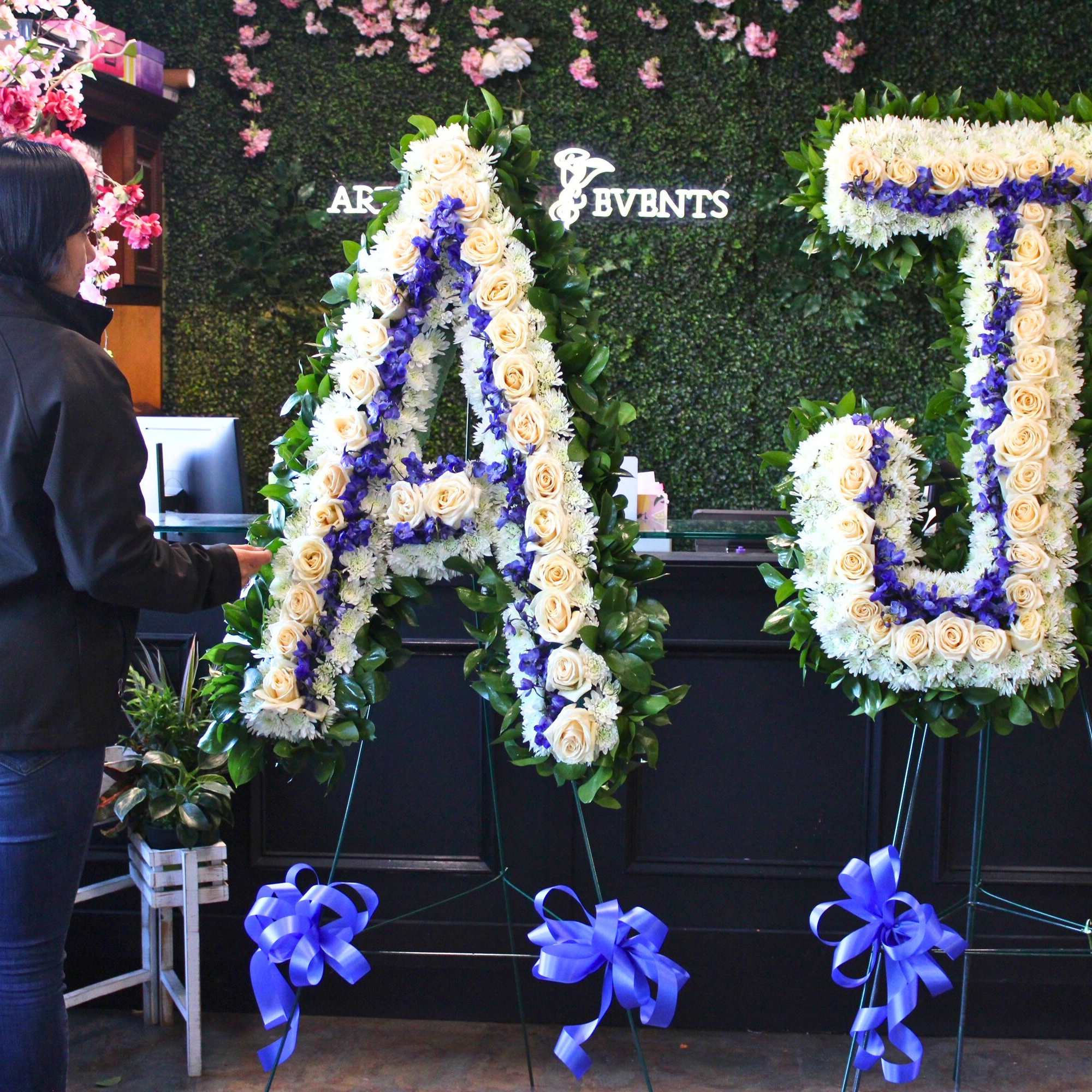 Large floral letter arrangements on stands with cream and purple flowers