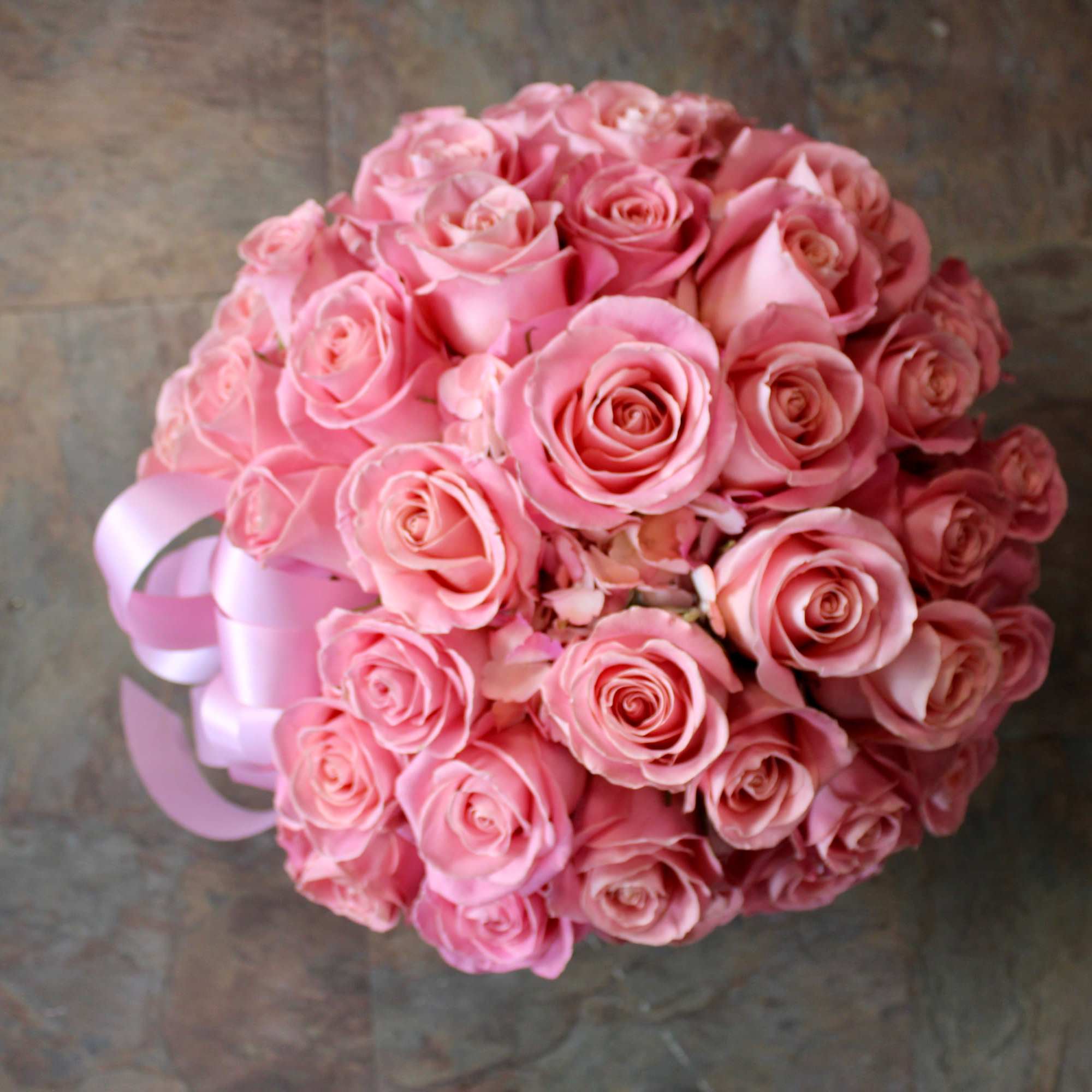 Round bouquet of pink roses tied with a pink ribbon