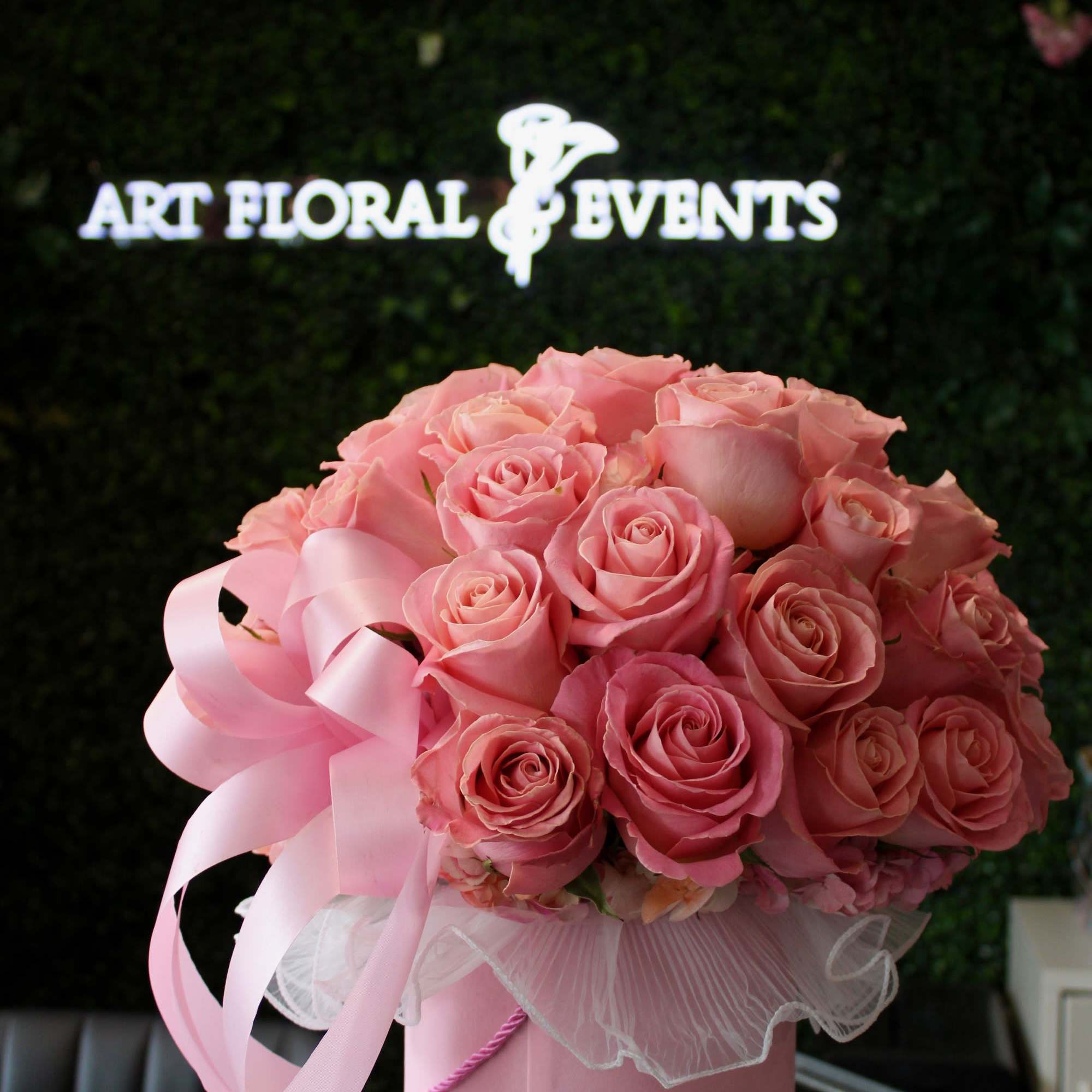 Pink rose bouquet in a round pink box with a ribbon bow