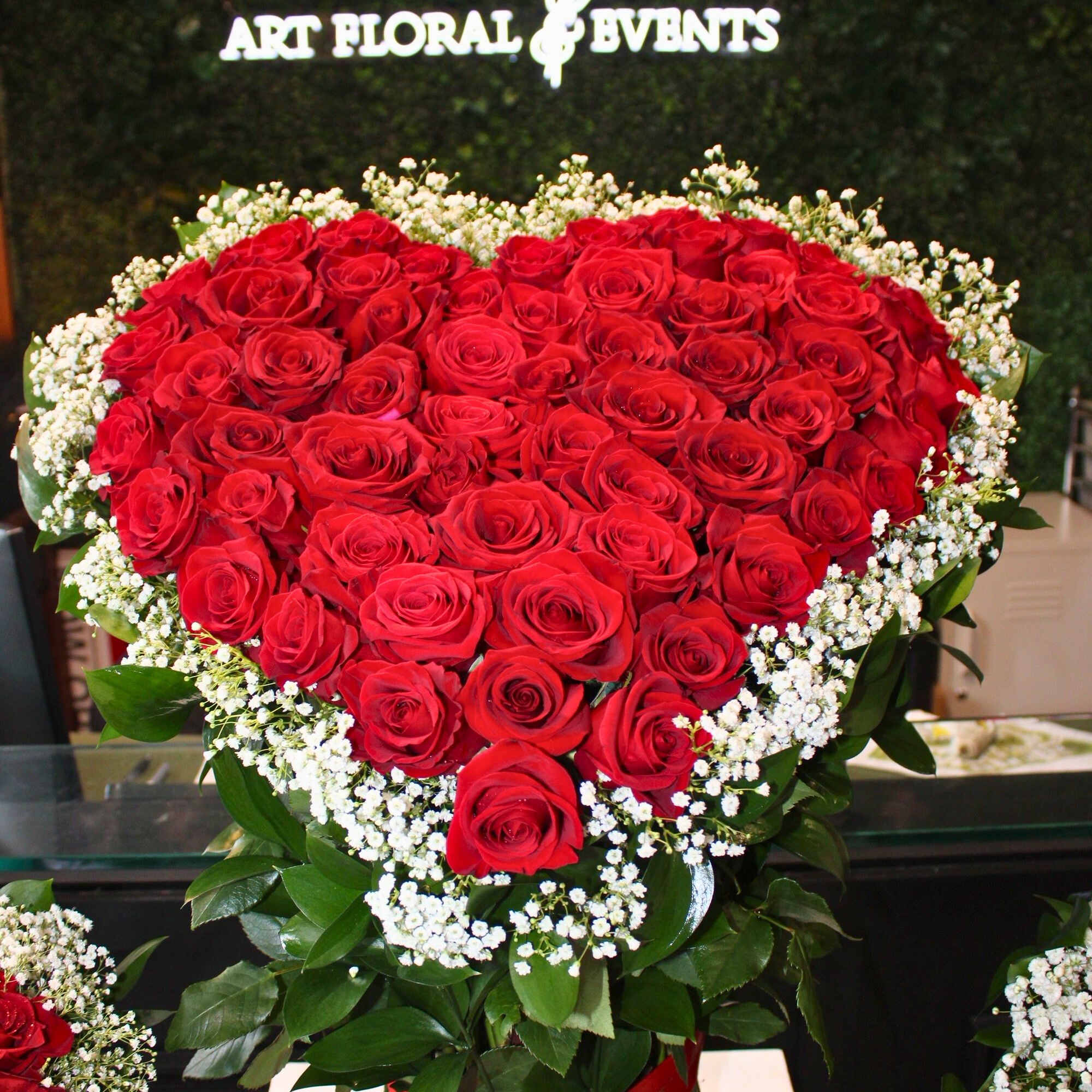 Heart-shaped bouquet of red roses with white baby's breath