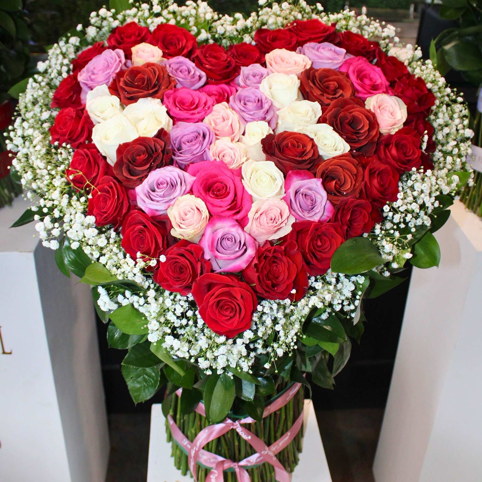 Heart-shaped bouquet of multicolored roses with baby's breath