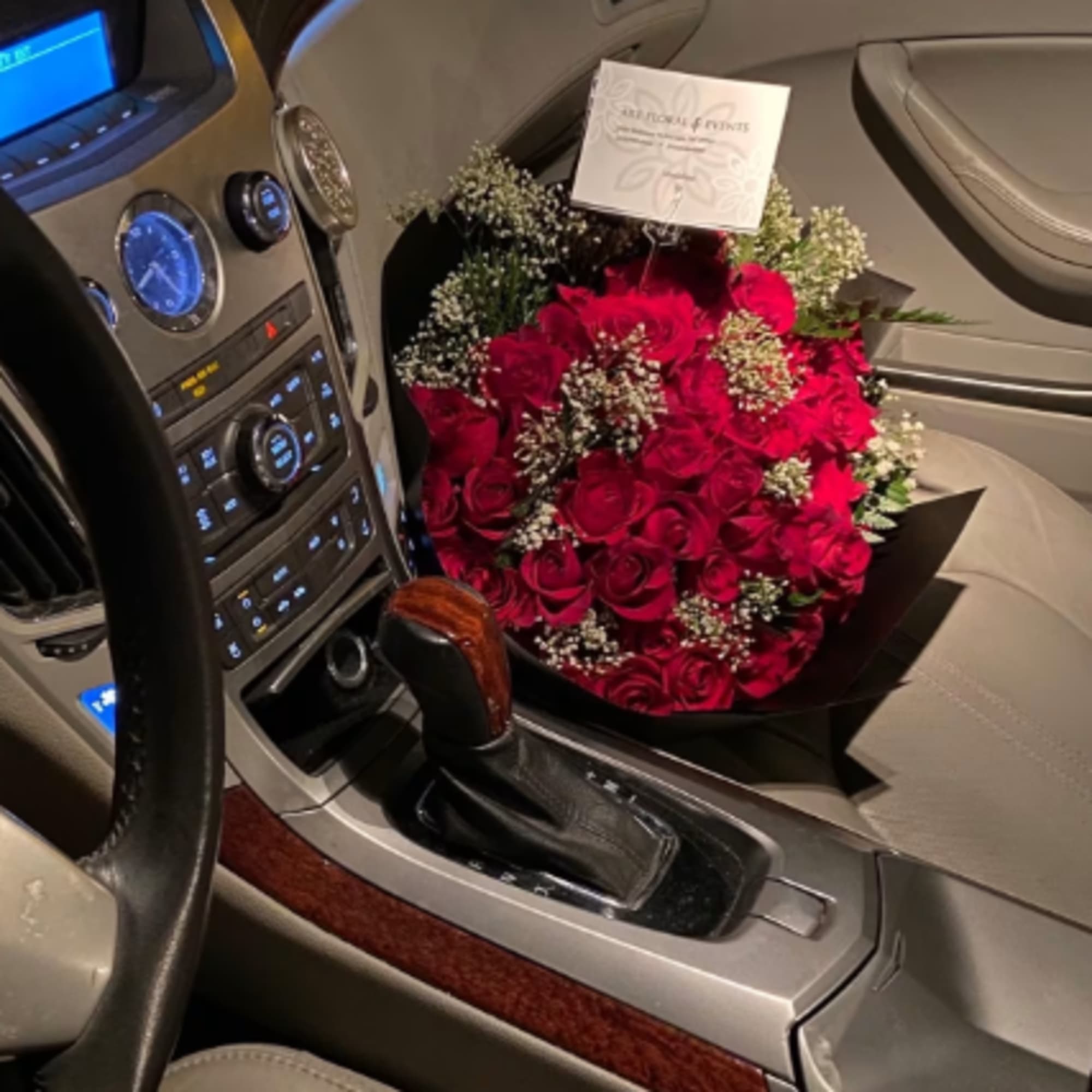 Bouquet of red roses with baby's breath on a car seat