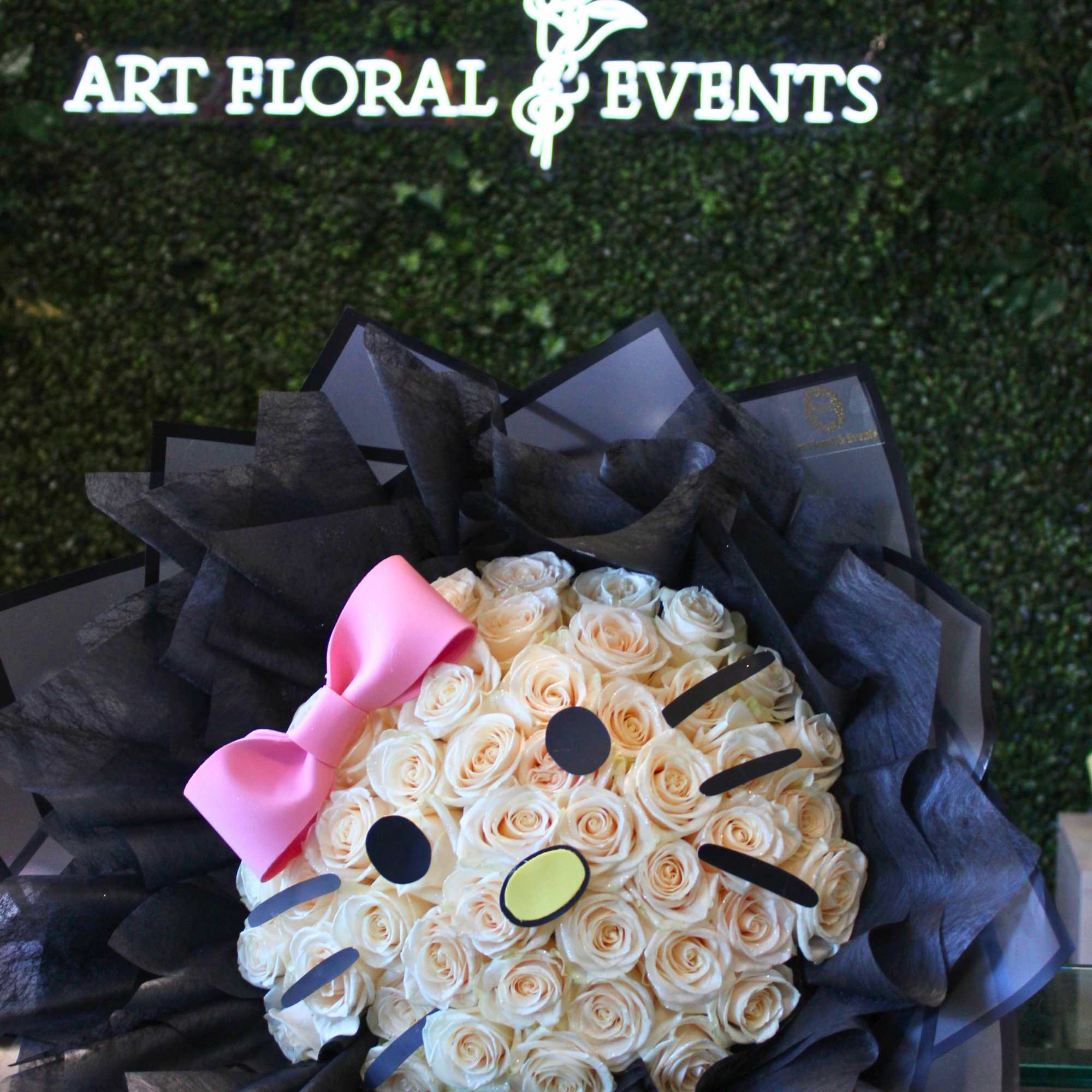 Bouquet of cream roses with a pink bow and black wrapping