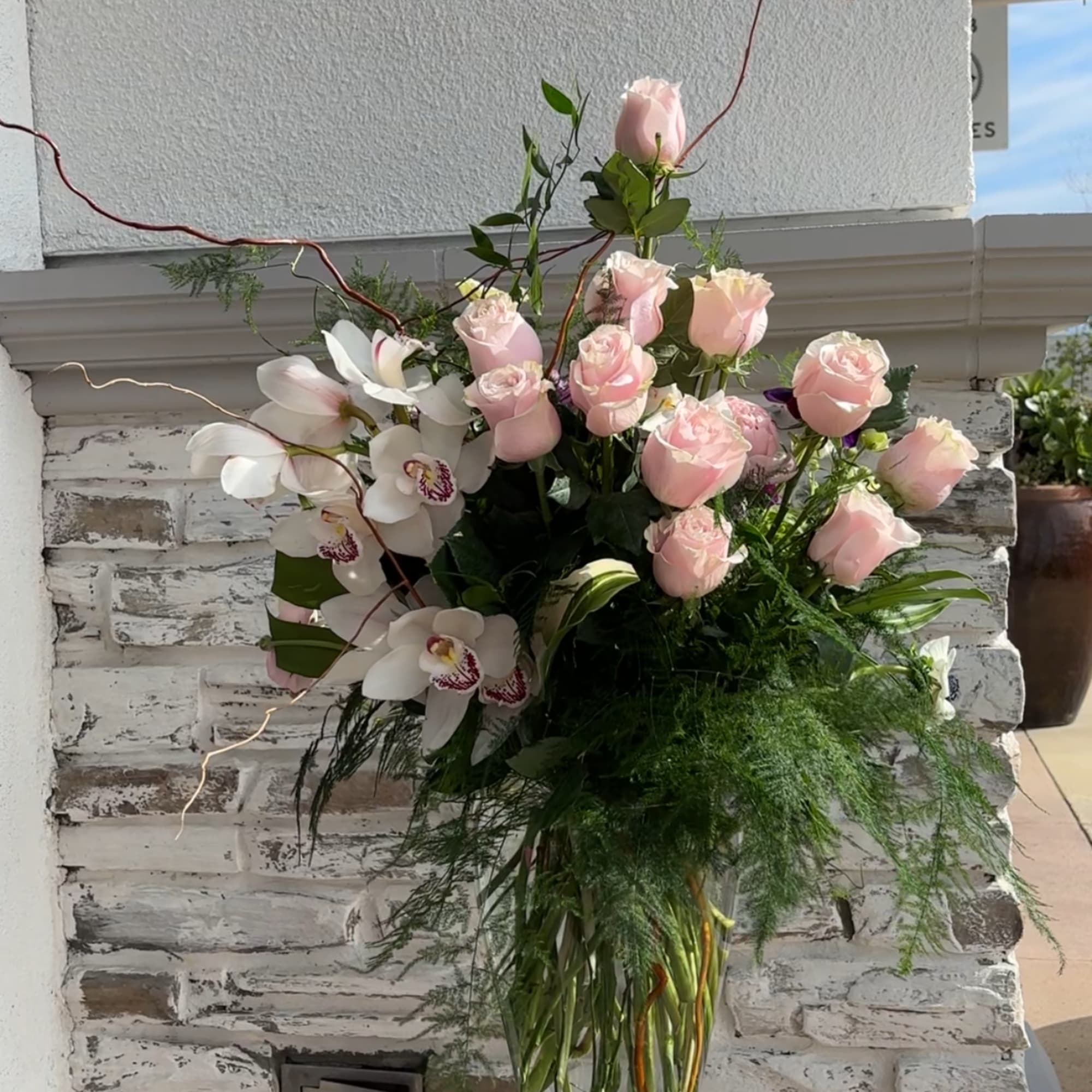 Pink roses and white orchids in a clear glass vase